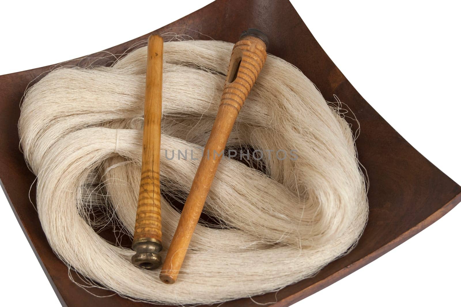Raw silk yarn and spools of old loom in wooden platter
