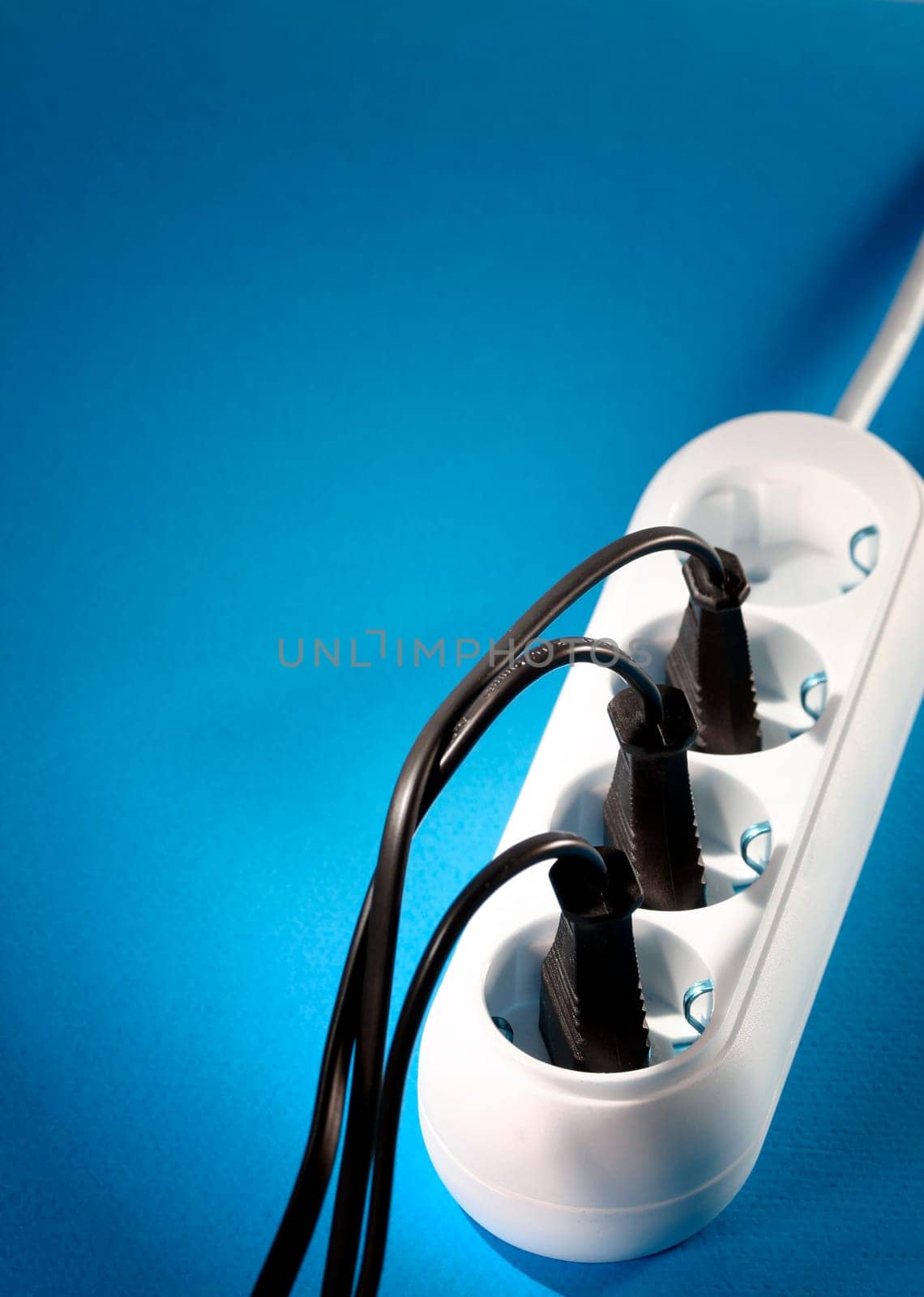 Closeup picture of a white outlet isolated on blue.