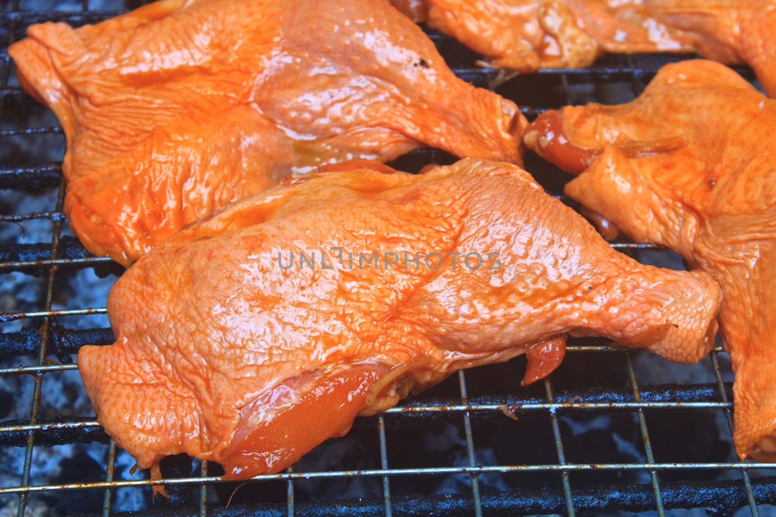Grilled chicken thigh on the flaming grill