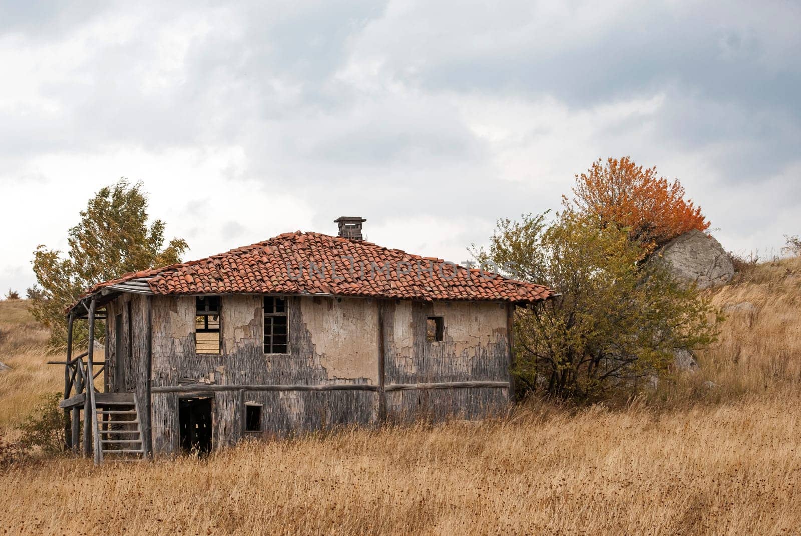 Abandoned house in the mountain on a cloudy autumn day