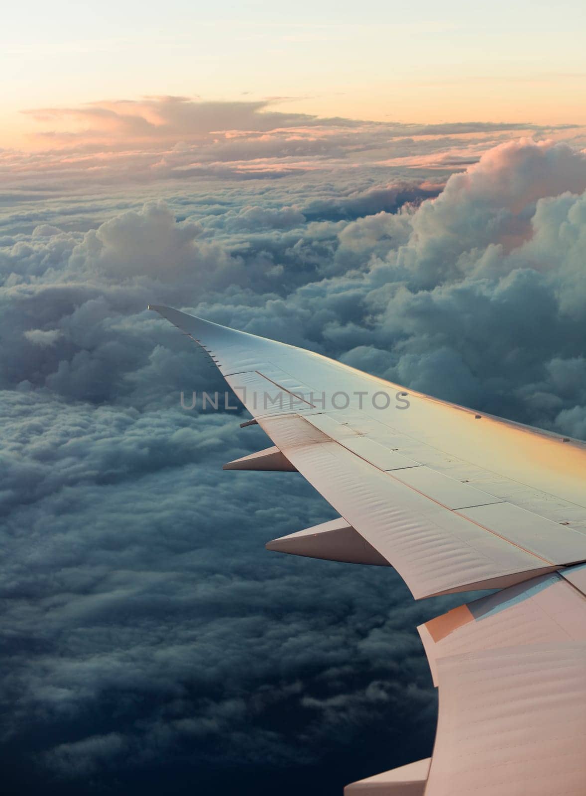 View of airplane wing with cloud patterns