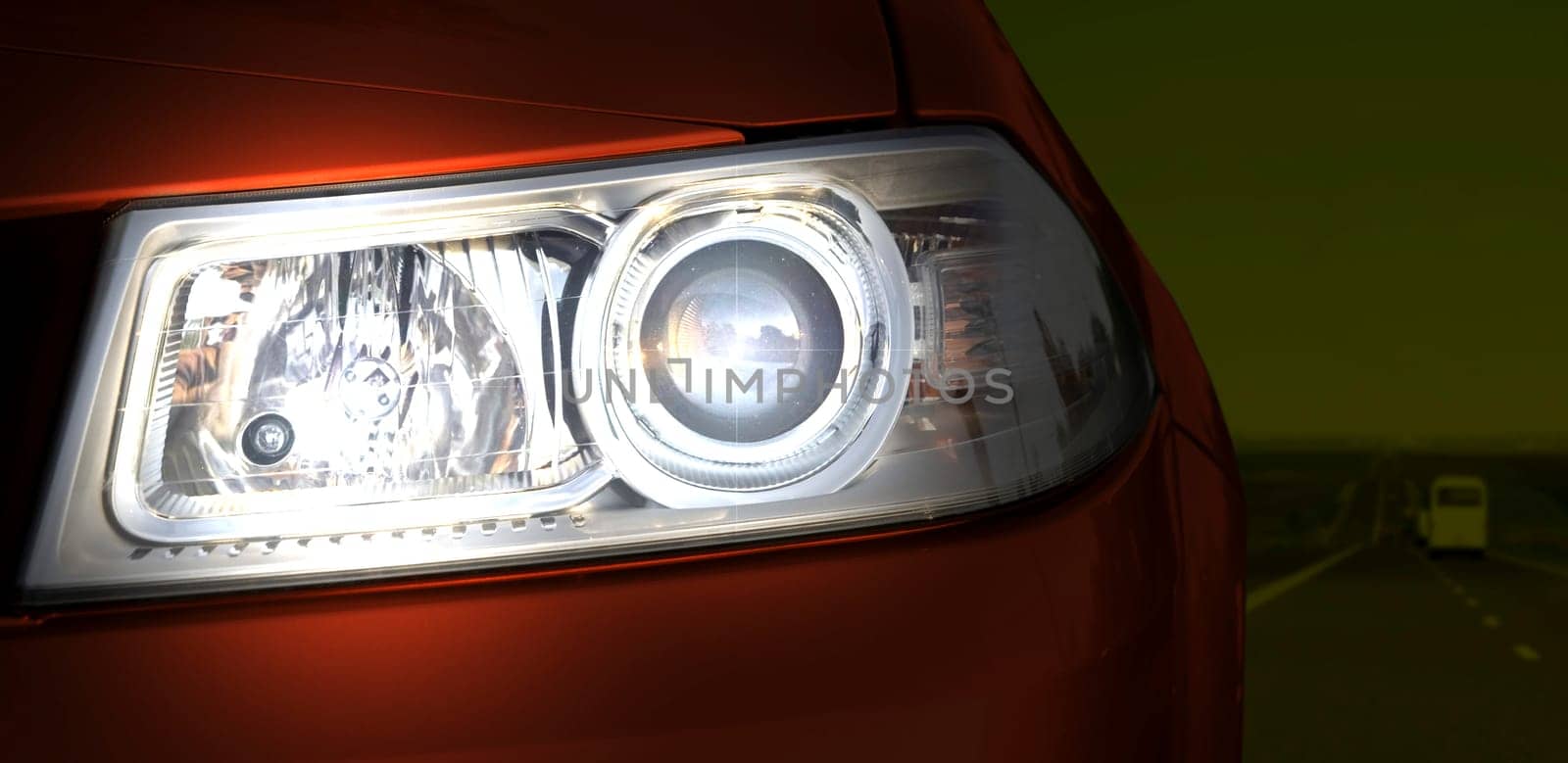 Car on the road. Close-up of the headlight.