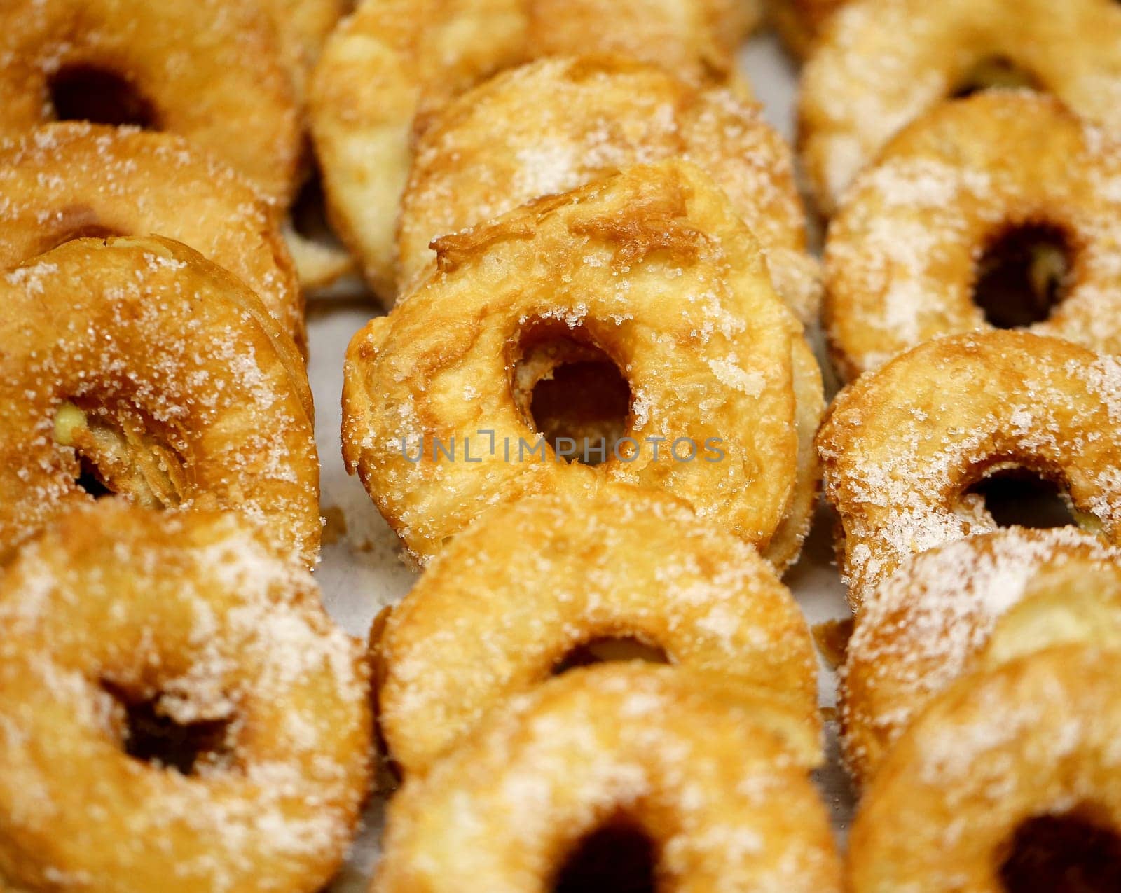 Round donuts sprinkled with white powder, packed in a row on the window