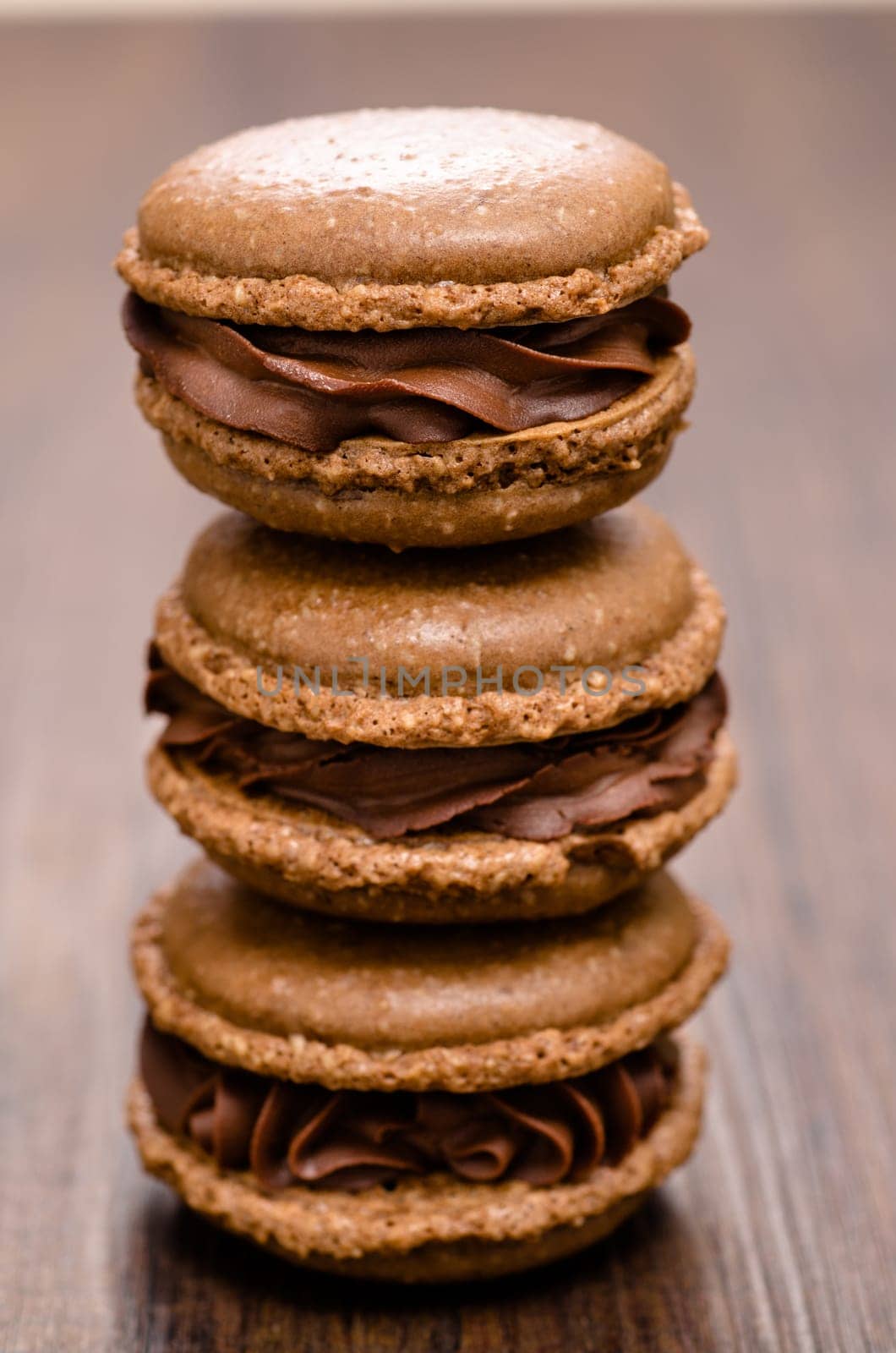 Three brown chocolate macarons on a stack