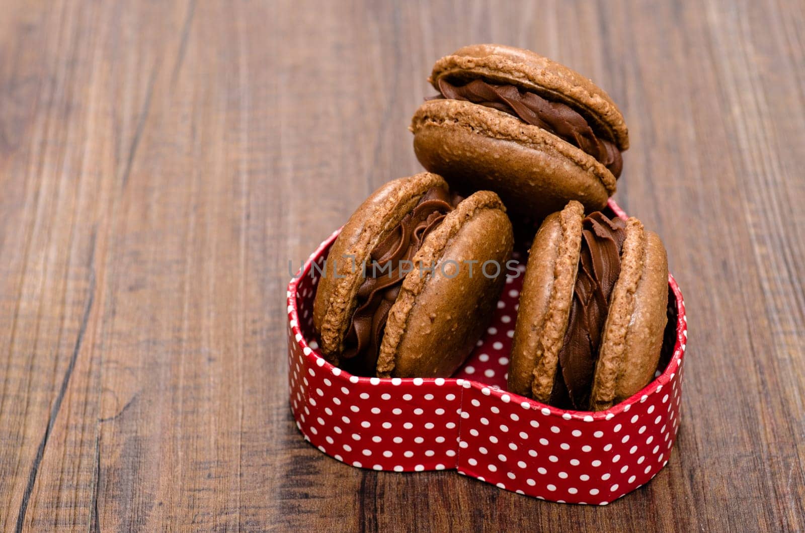 Macarons with chocolate in a box as a heart