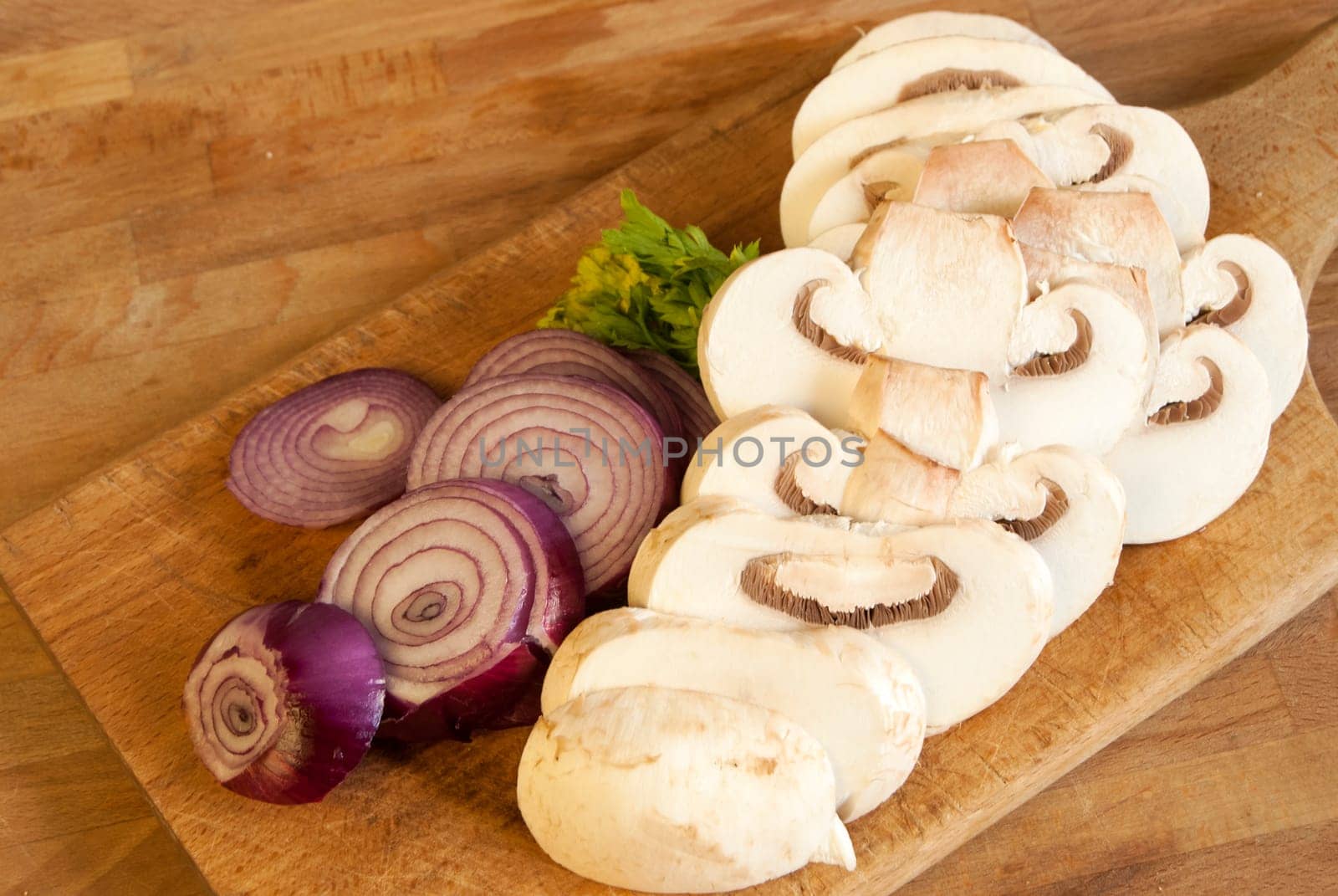 Chopped fresh raw onion and mushroom on a wooden board