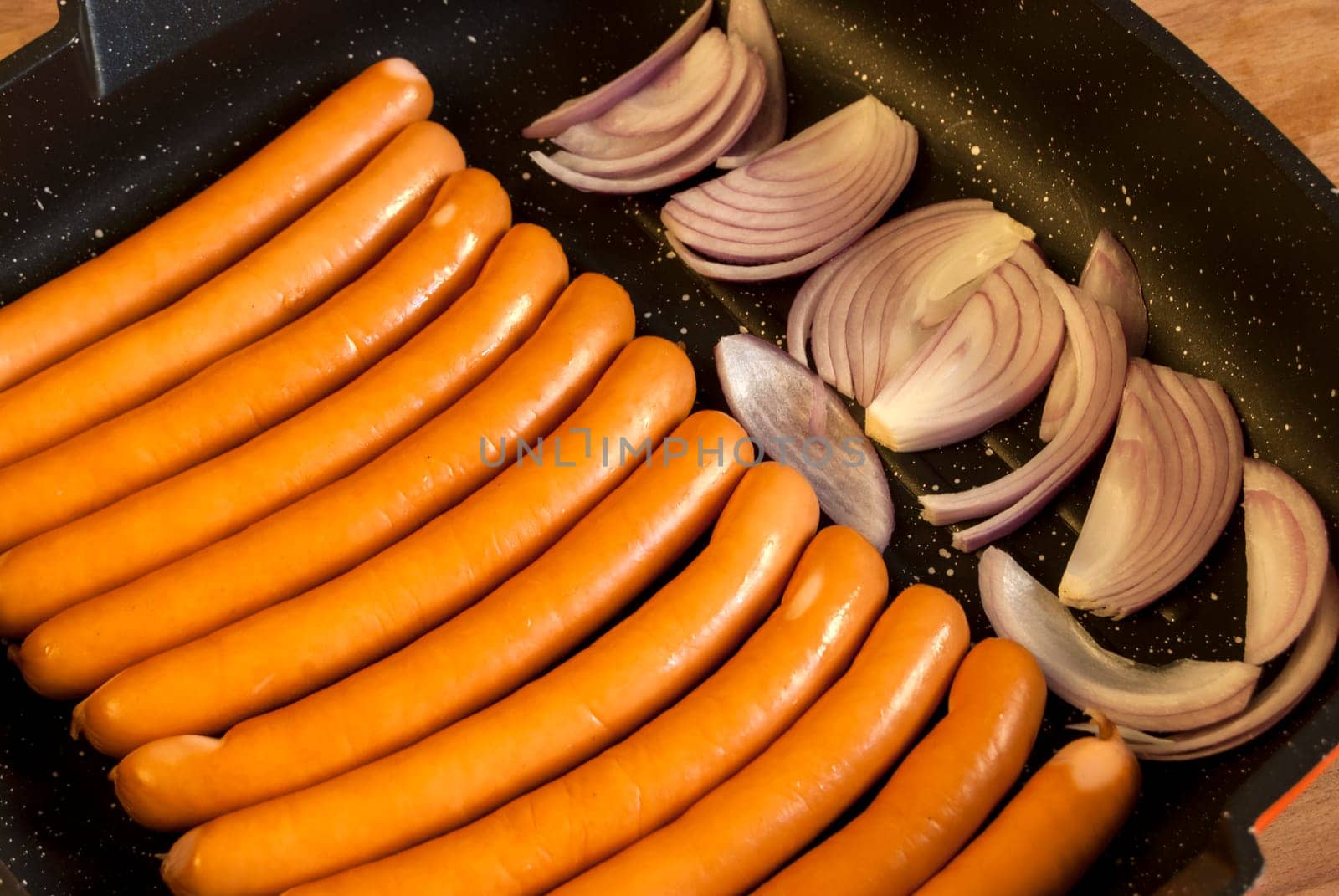 Sausages and onions prepared for frying in pan