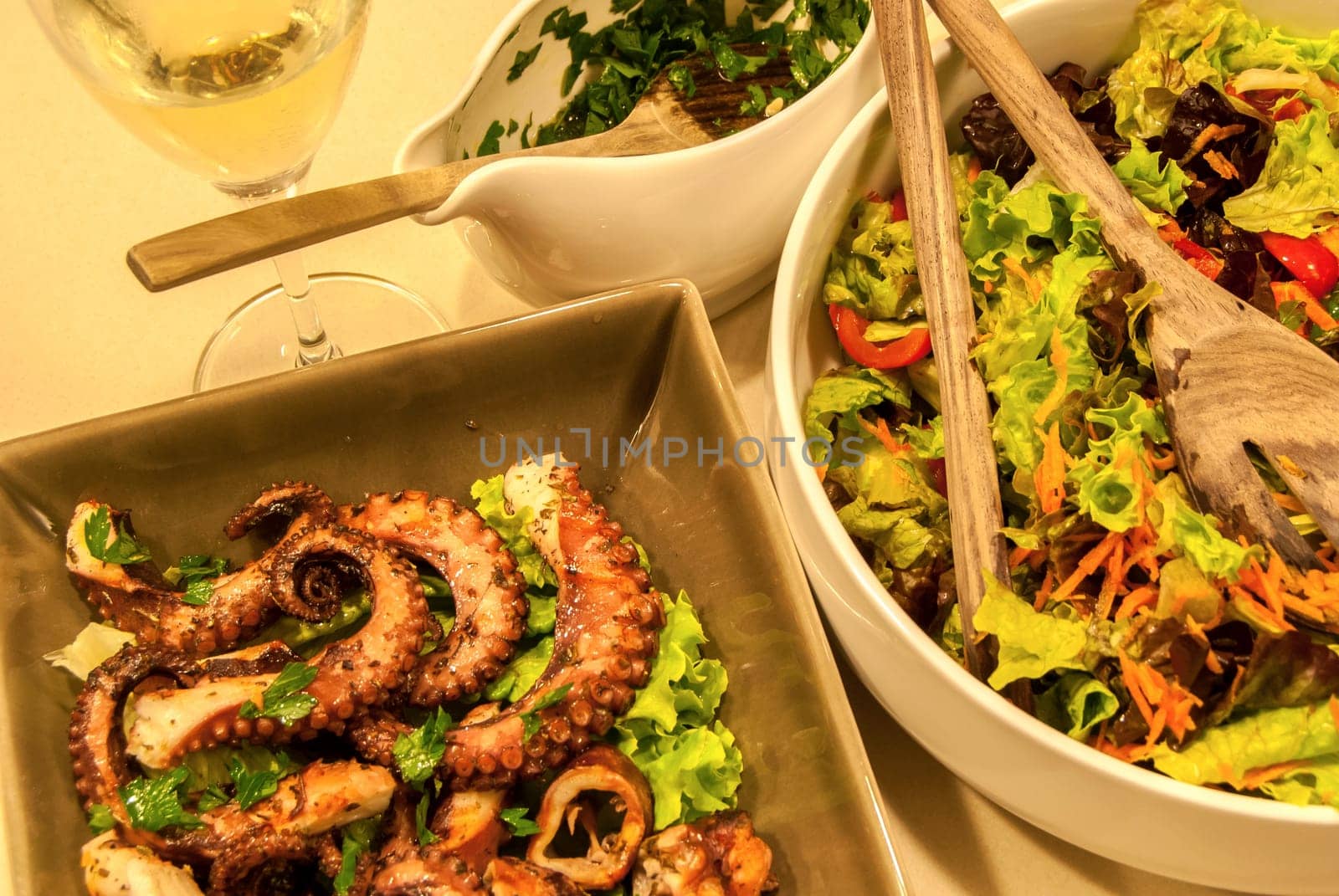 Fried octopus with olive oil and fresh salad dishes