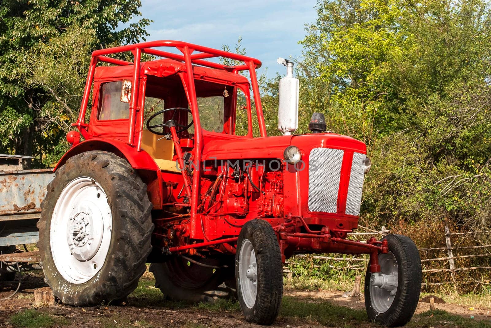 Vintage red grunge tractor on rural landscape