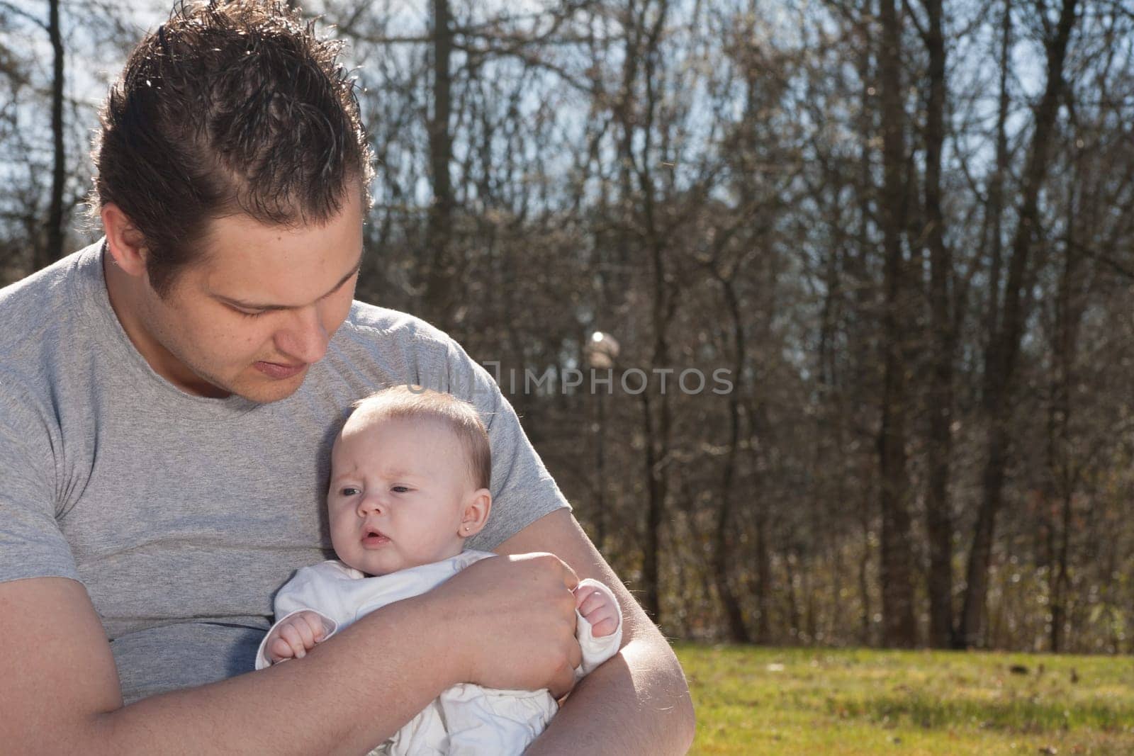Young father is having some nice time with his baby on a sunny day