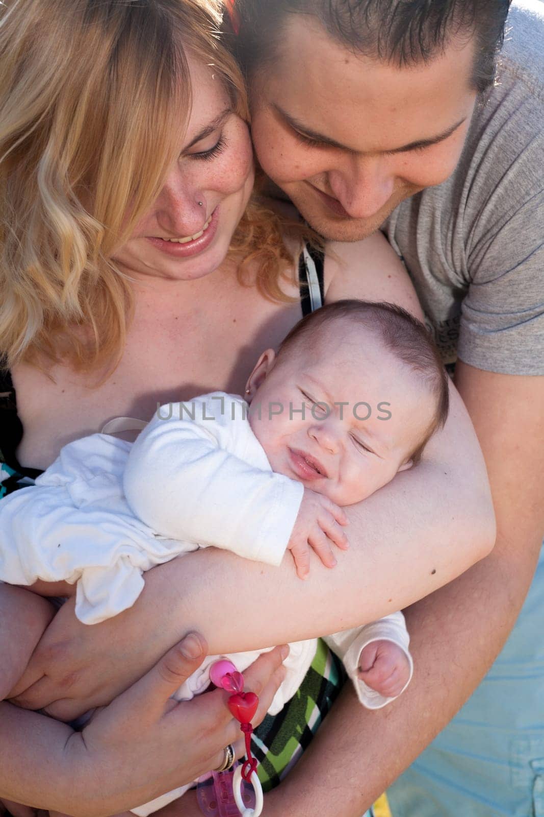 Young family is having  nice time with their baby on a sunny day