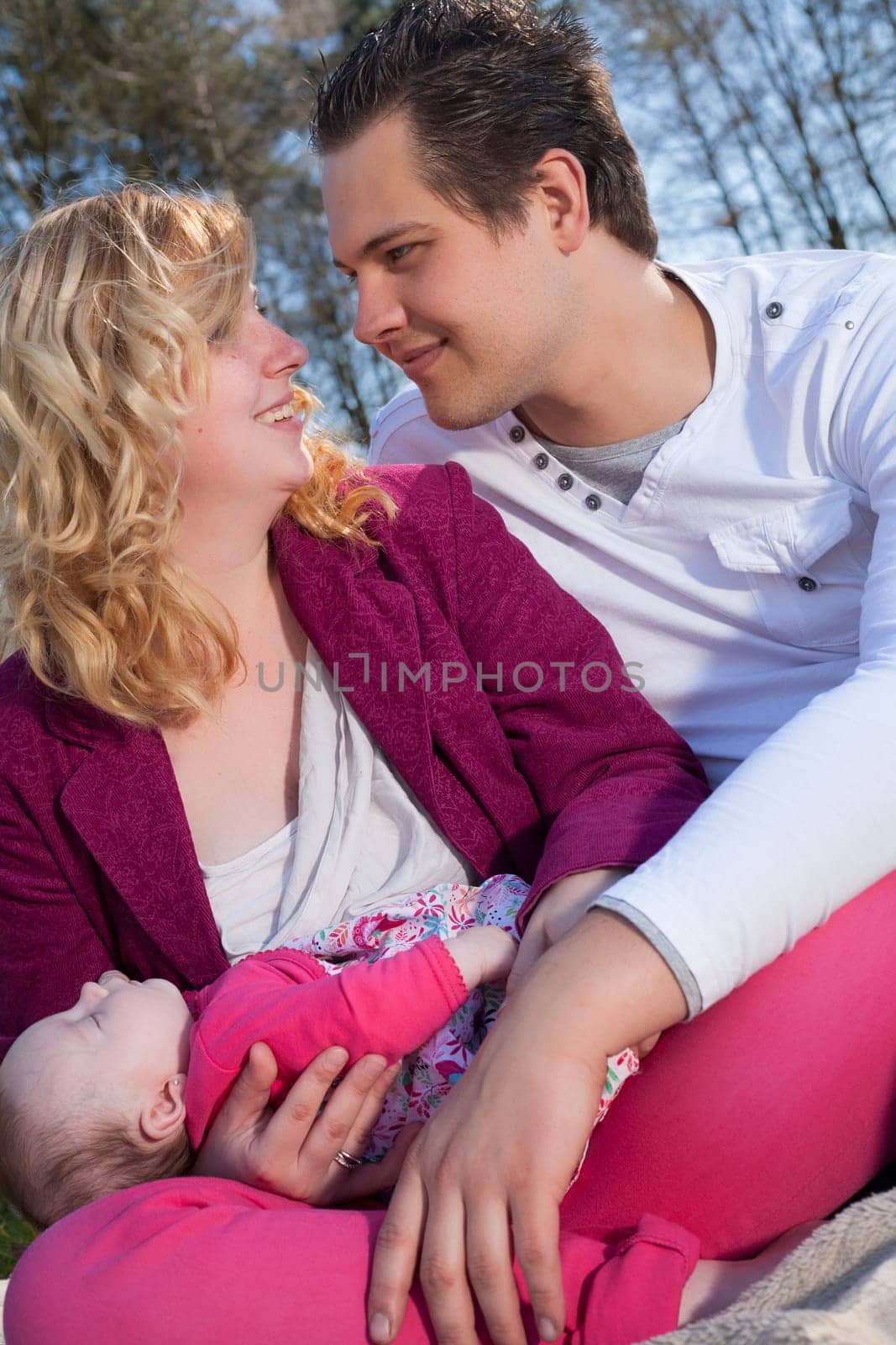 Young family is having  nice time with their baby on a sunny day