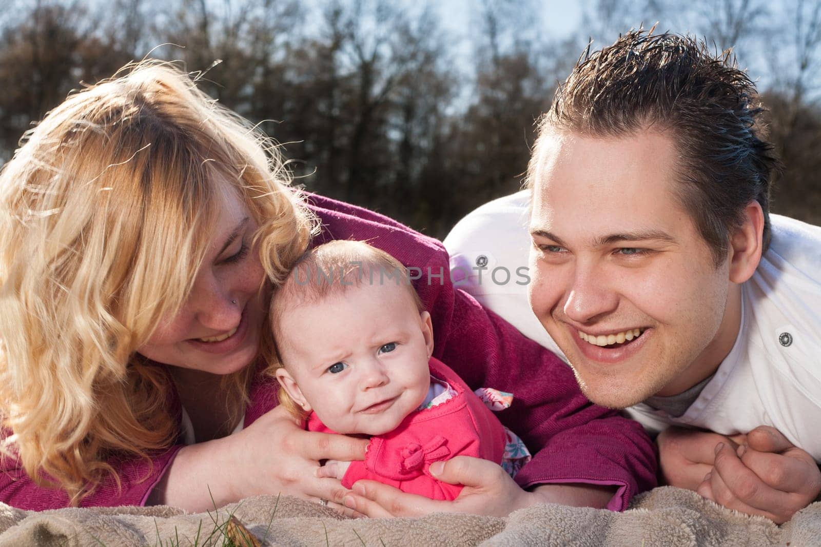 Young family is having  nice time with their baby on a sunny day
