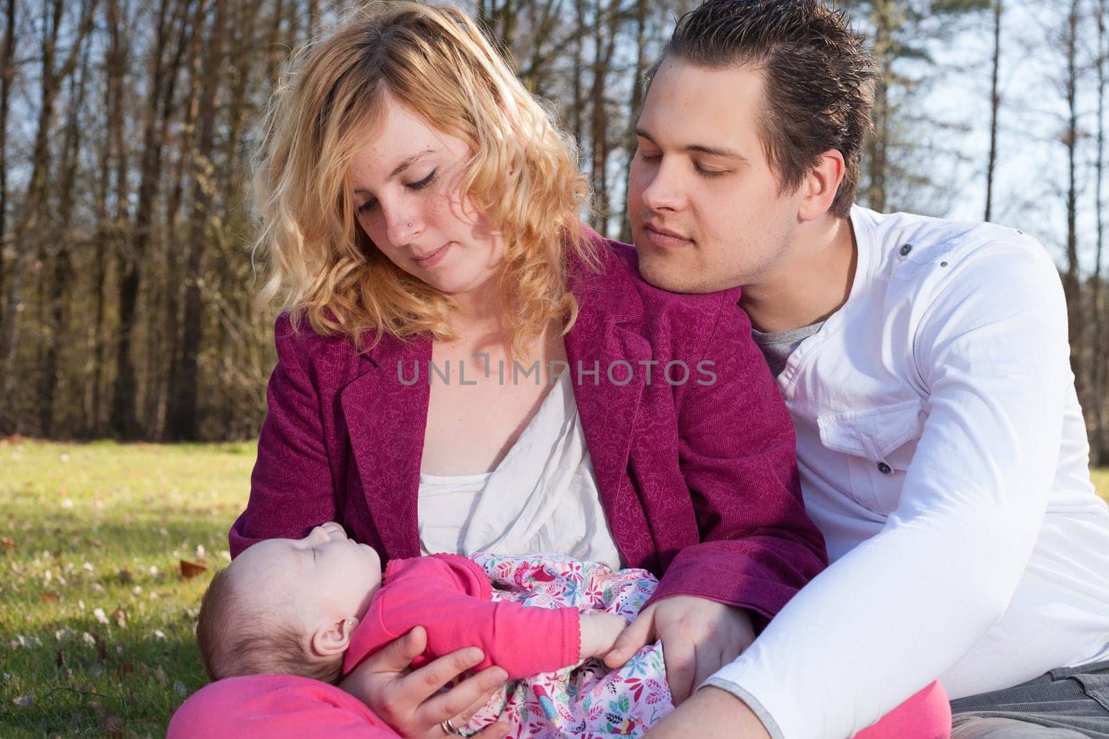 Young family is having  nice time with their baby on a sunny day