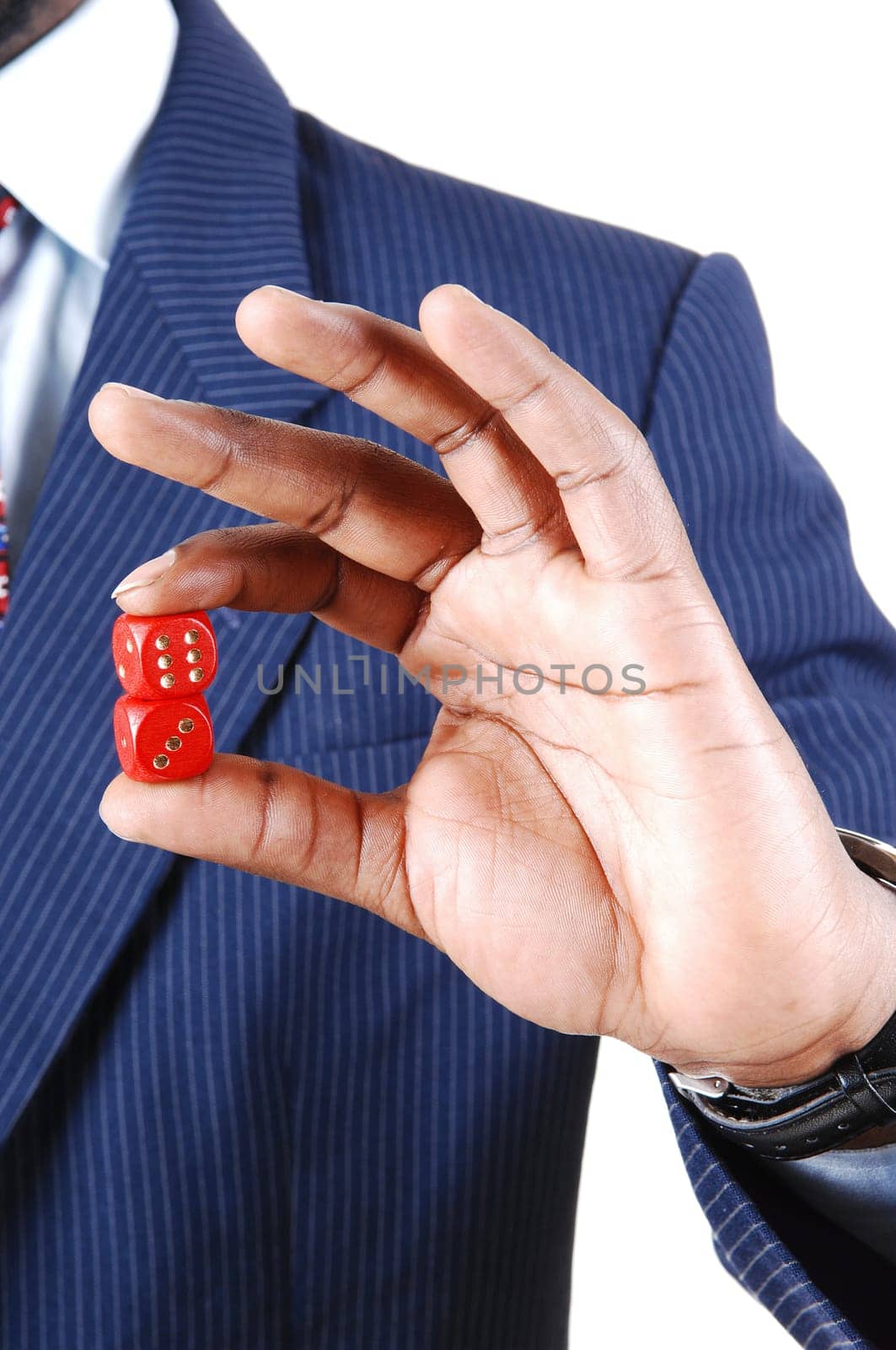 A black businessman holding two red dice in his hand, in a blue suit.standing isolated for white background..