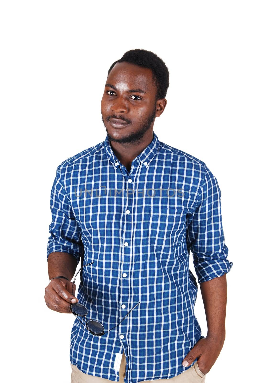 A young handsome black man in a blue shirt with a sunglass in his hand.standing isolated for white background..