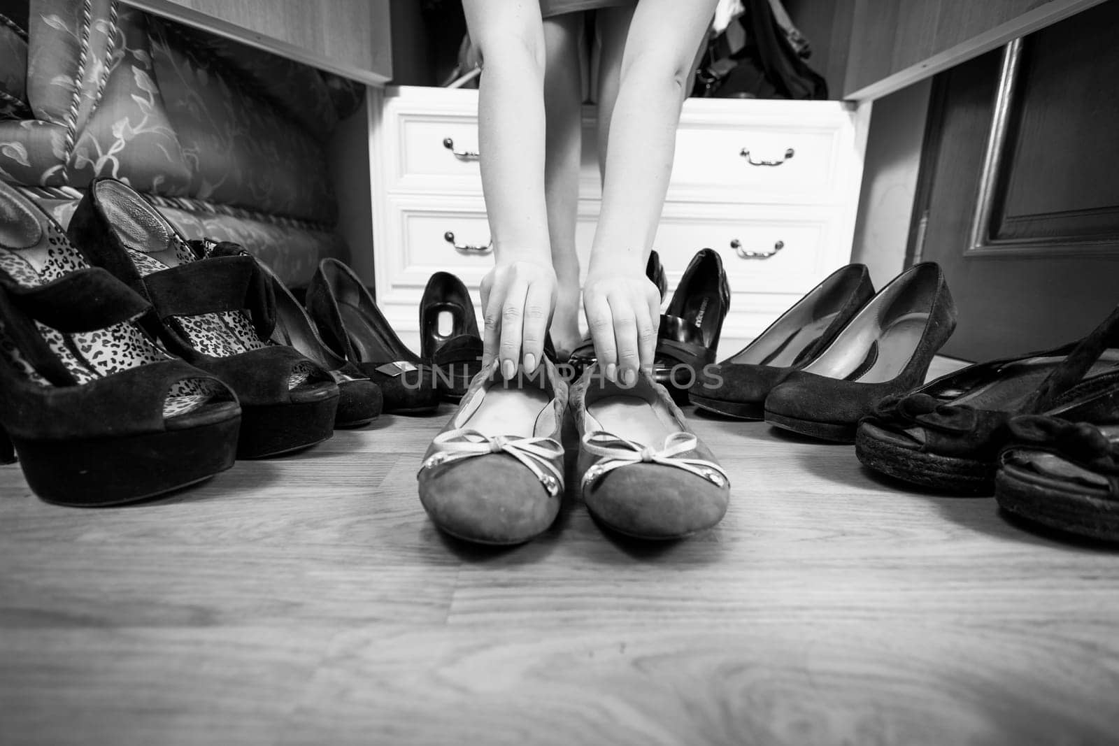 Black and white photo of woman holding ballet flats rather then high heels