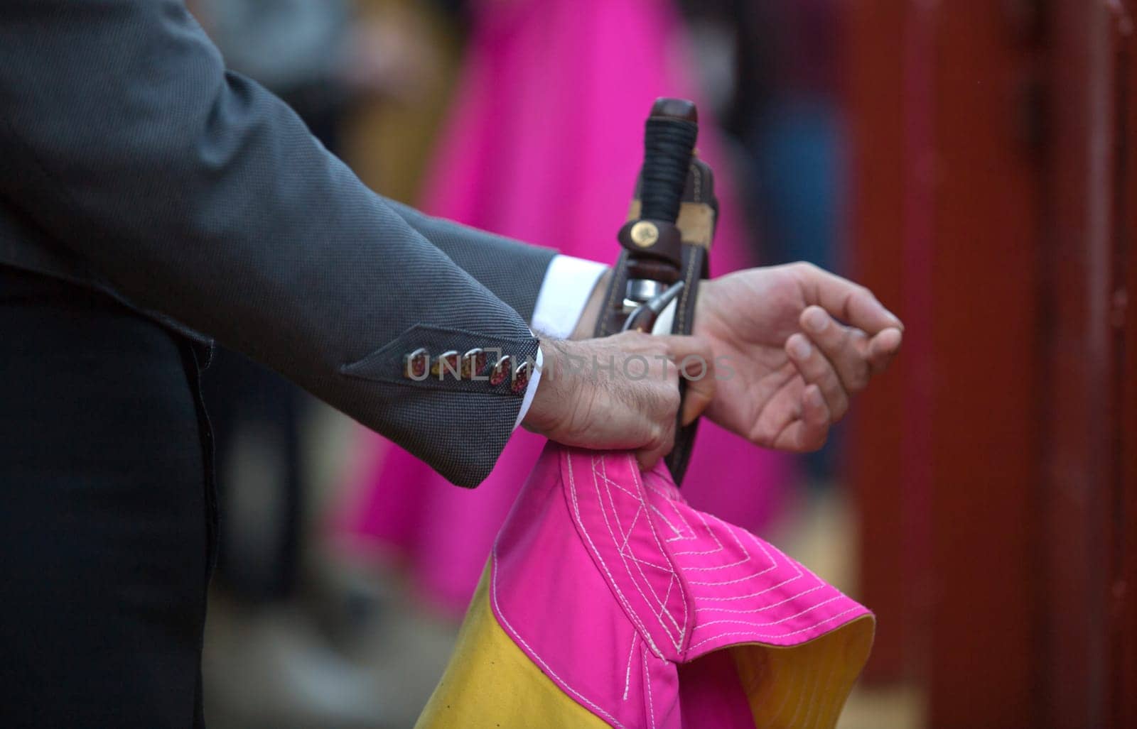 The bullfighter prepares his daggers behind the barrier of the bullring