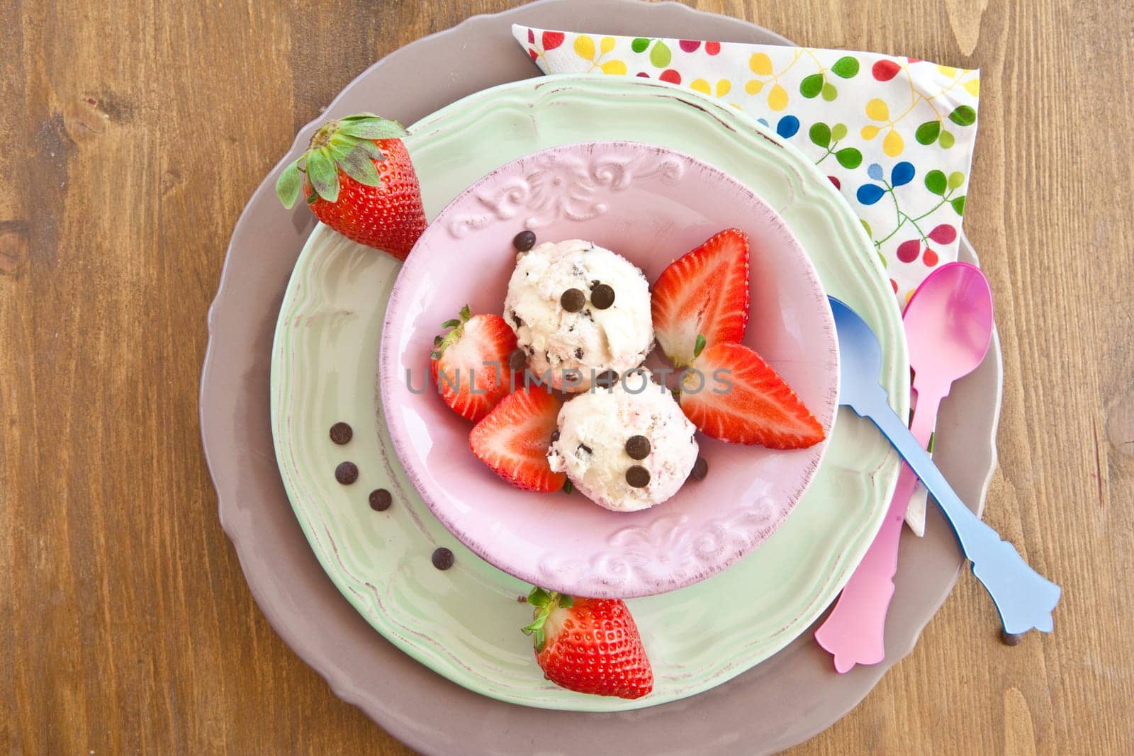 Ice cream with strawberries and chocolate in pink scounda