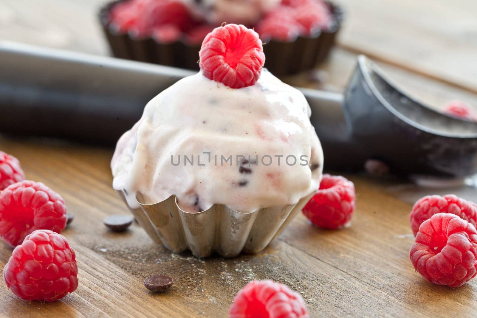 Ice cream with raspberries and chocolate on rustic wood