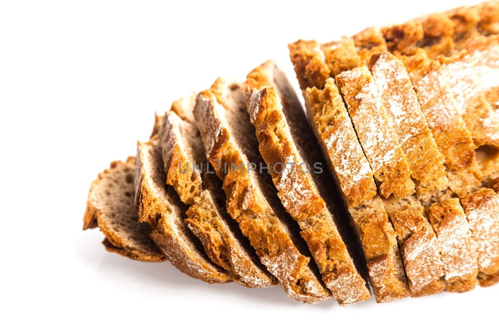Freshly baked sliced loaf of rye bread viewed from a high angle close up on white with copyspace
