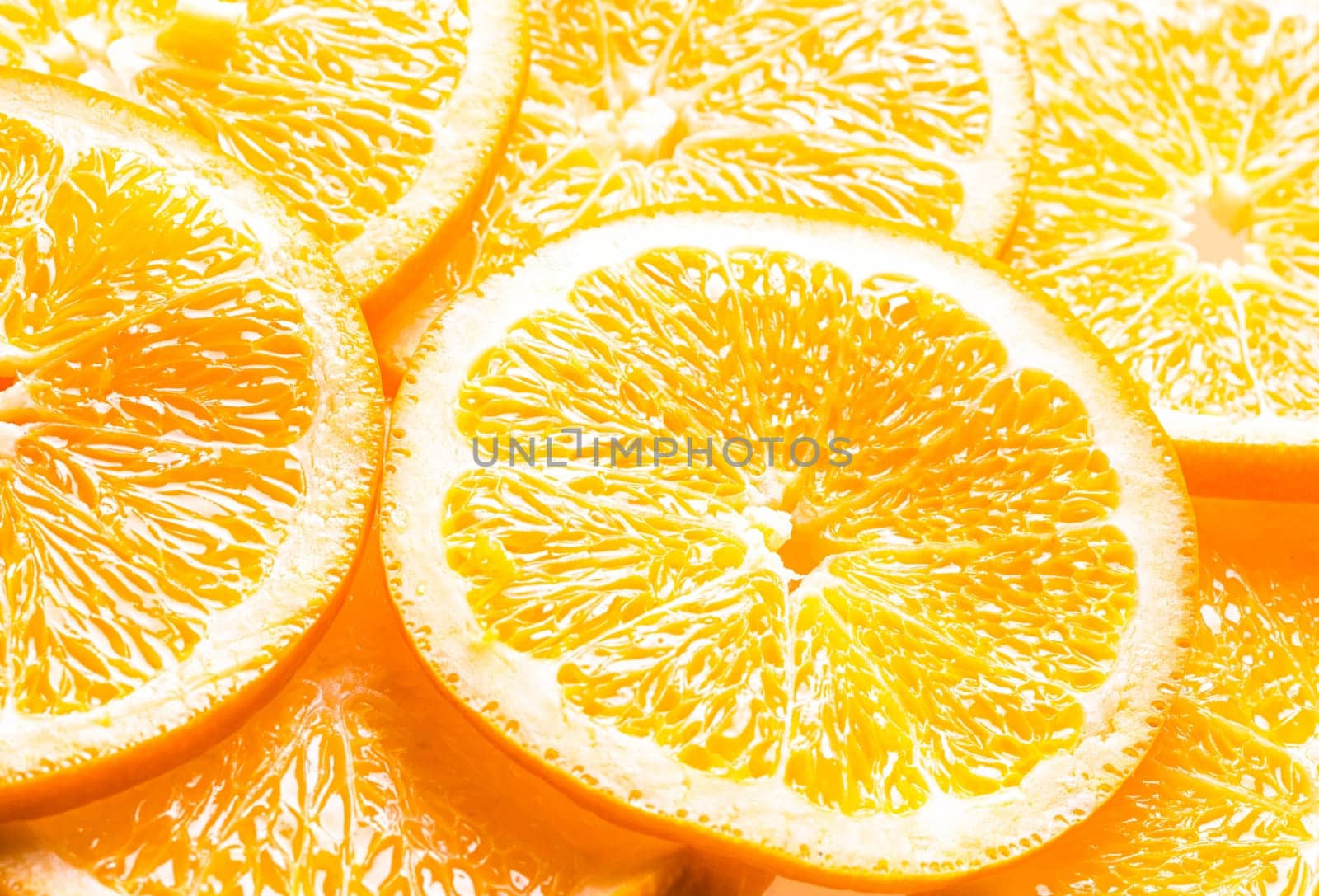 Full frame background of juicy orange slices showing the texture of the pulp, pith and rind with an angled perspective