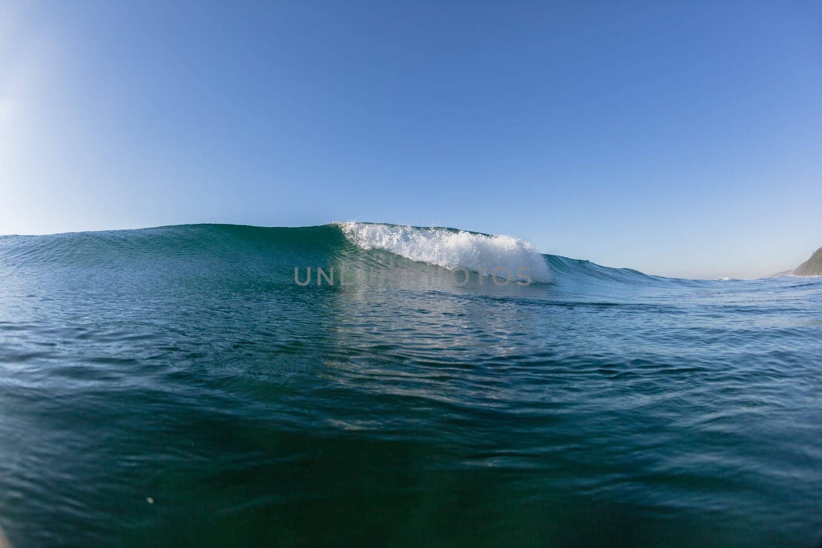 Ocean wave crashing water power energy on shallow reefs nearby beach coastline
