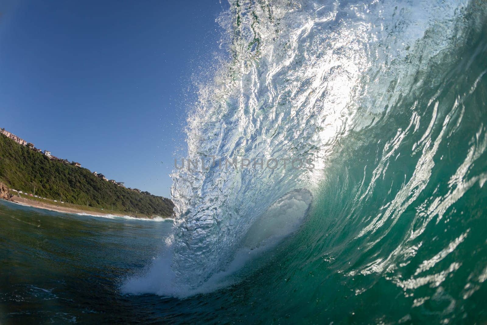 Ocean wave crashing water power energy on shallow reefs nearby beach coastline