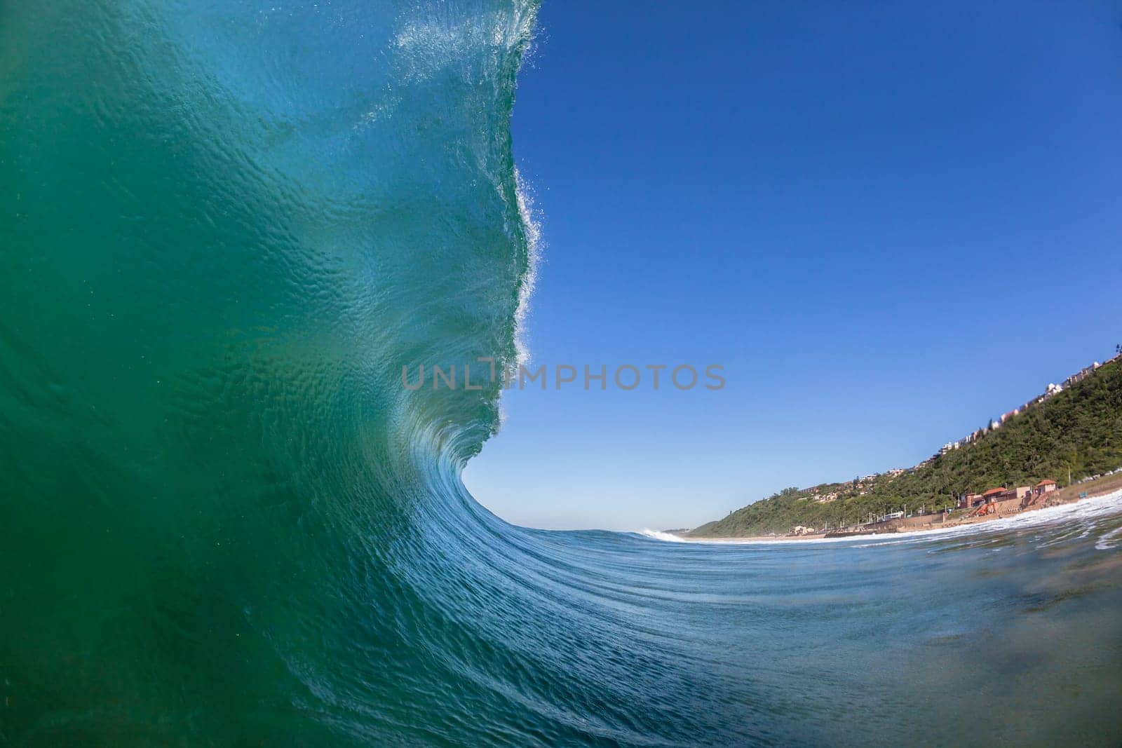 Ocean wave crashing water power energy on shallow reefs nearby beach coastline