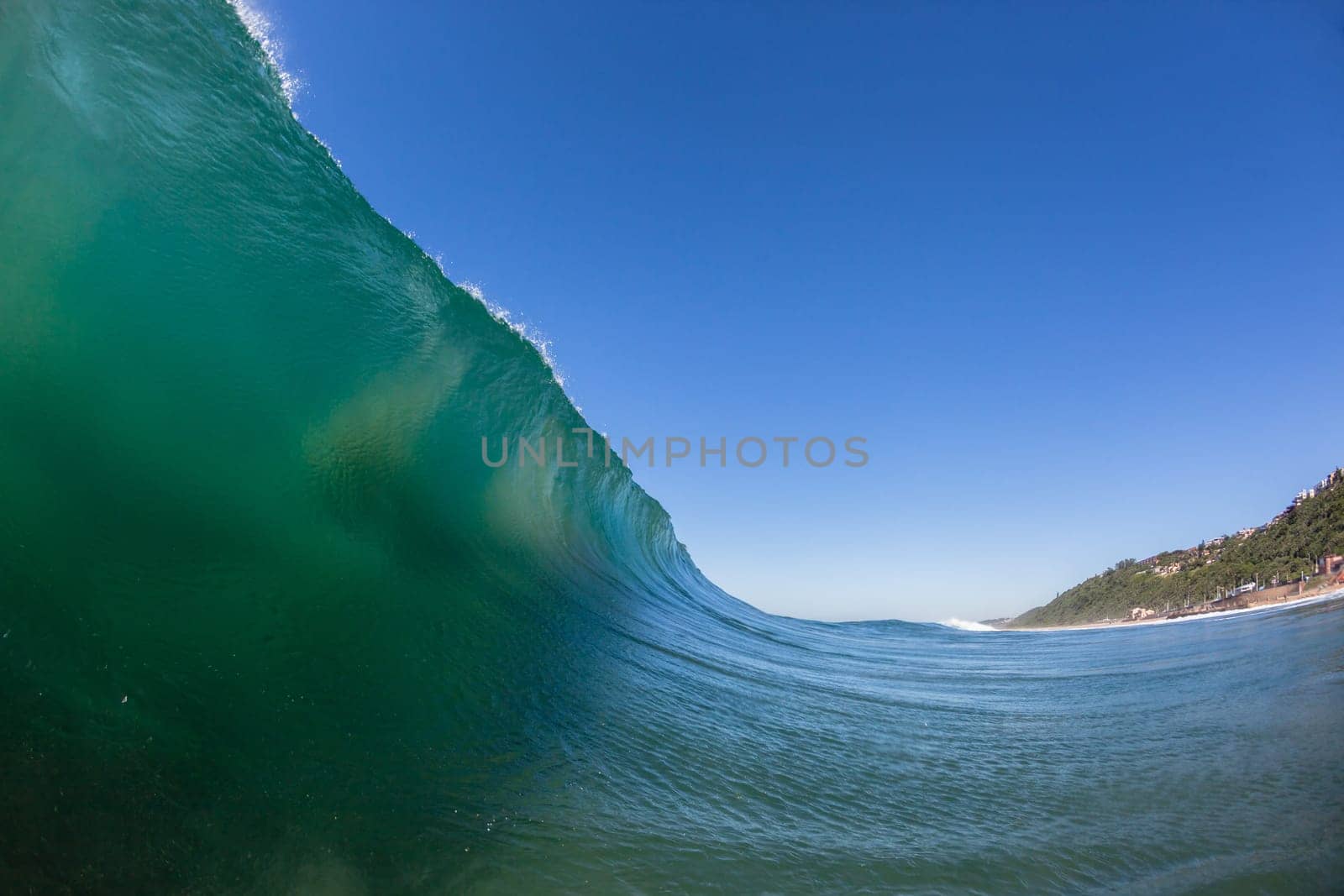 Ocean wave crashing water power energy on shallow reefs nearby beach coastline