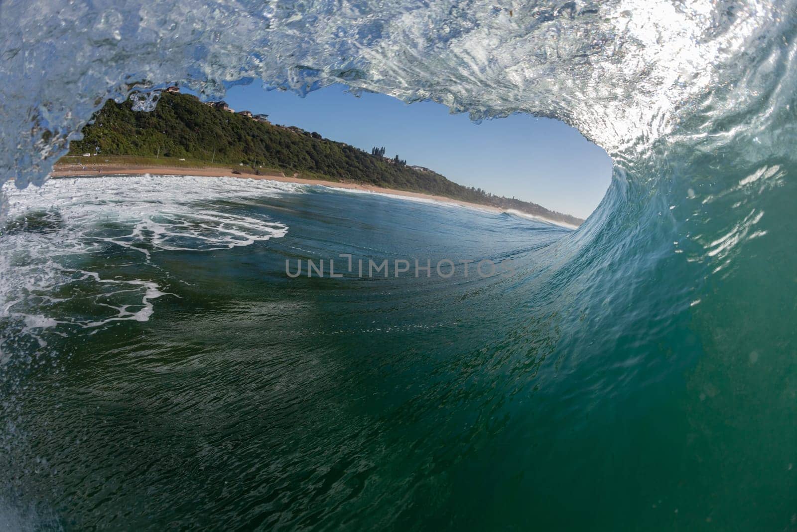 Ocean wave crashing water power energy on shallow reefs nearby beach coastline