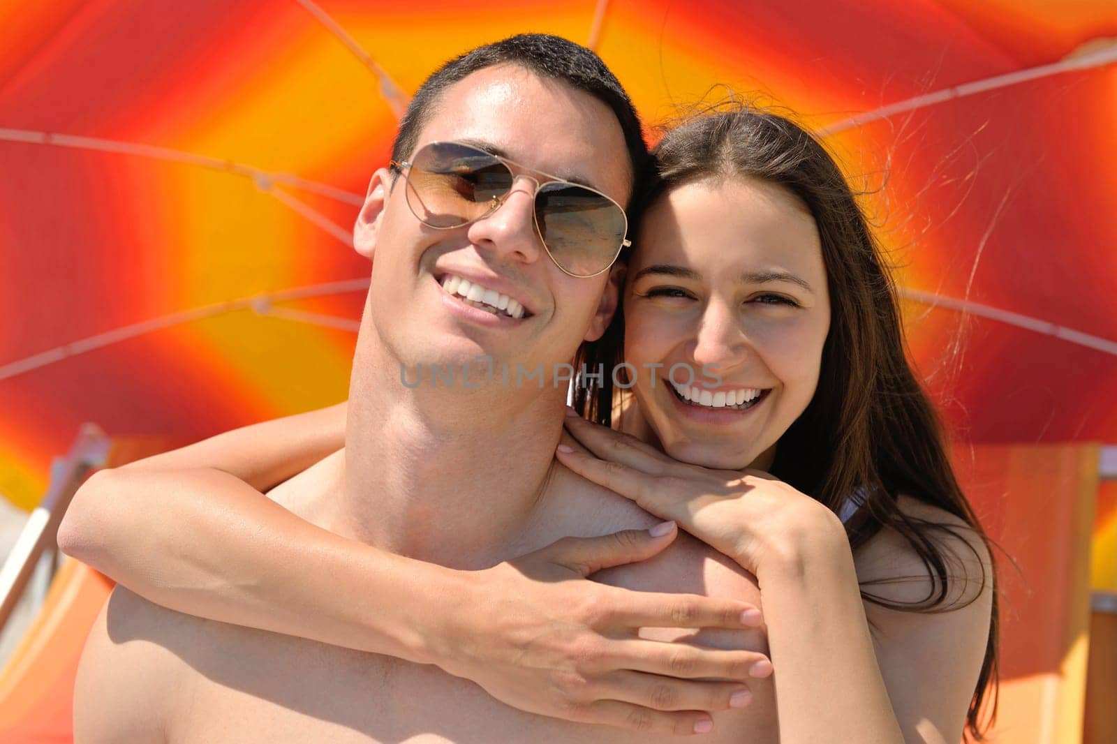 happy young couple have fun and relax  on the summer with heart drawing on beach sand