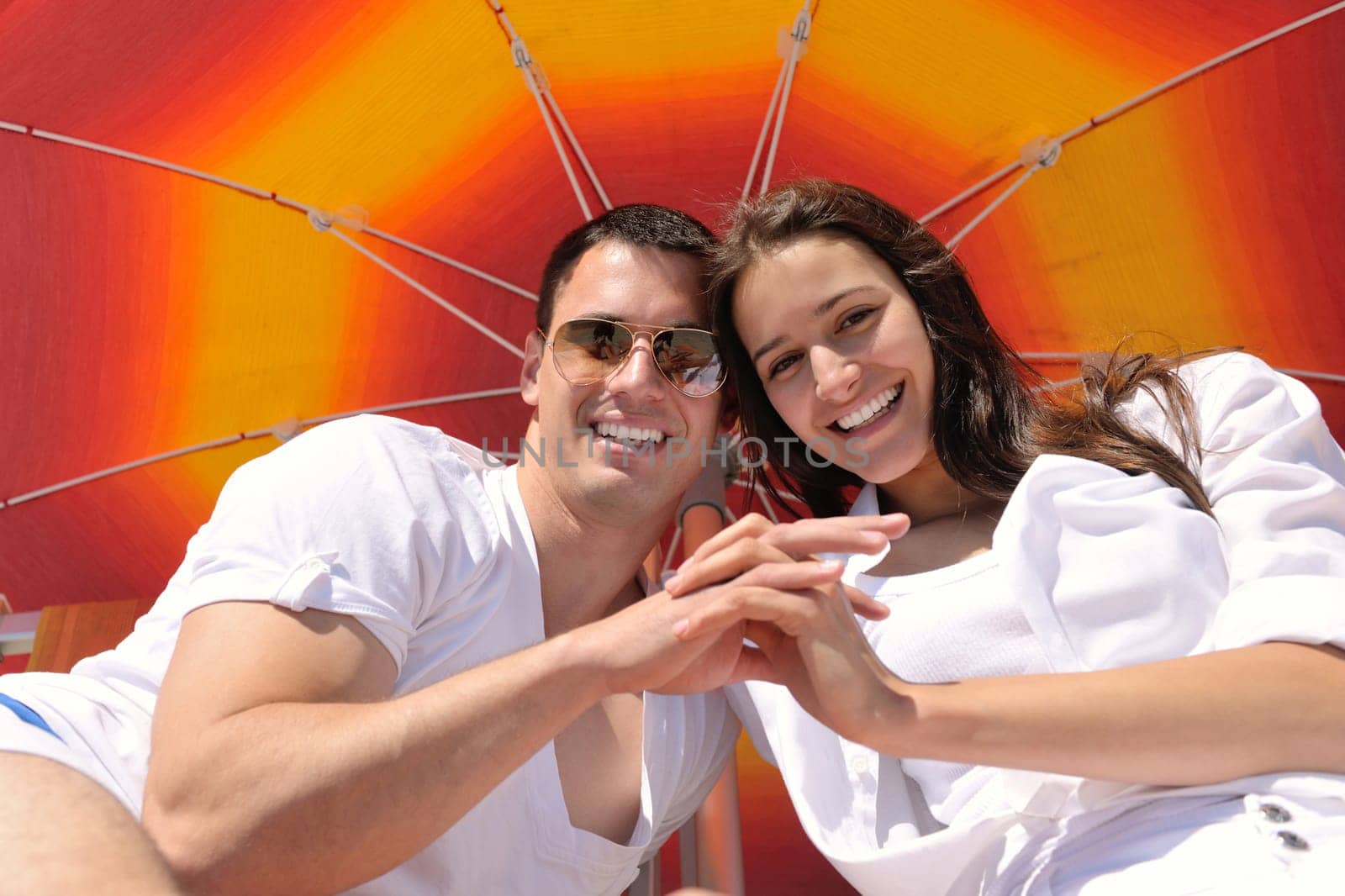 happy young couple have fun and relax  on the summer with heart drawing on beach sand