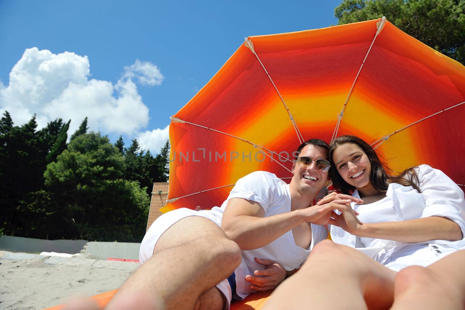 happy young couple have fun and relax  on the summer with heart drawing on beach sand