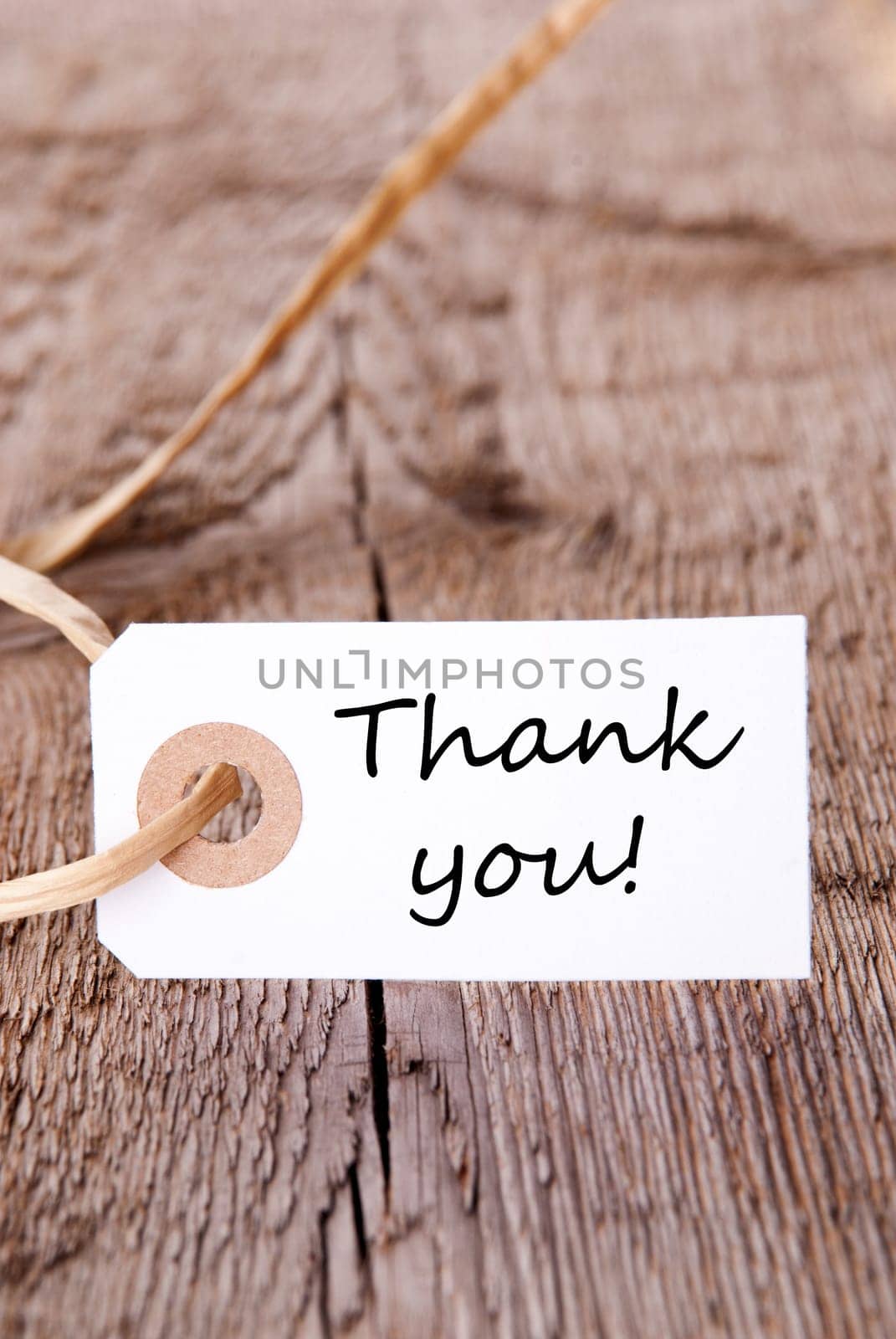 The Words Thank You on a White Label on a wooden Plank