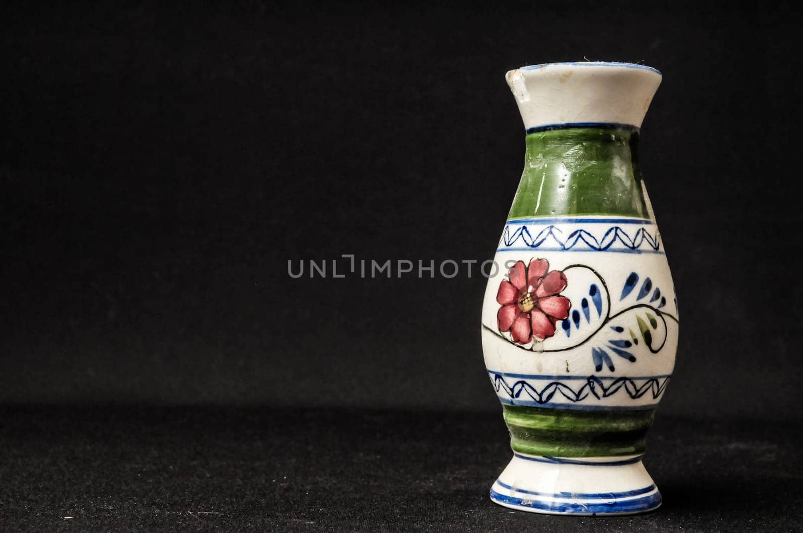 Colorful designed clay vase over a Black background