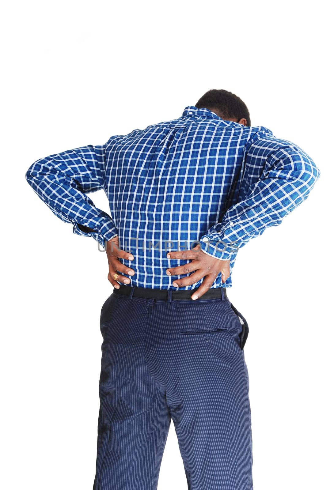 A young black man standing isolated for white background, holding his .hands on his back for heavy back pain..