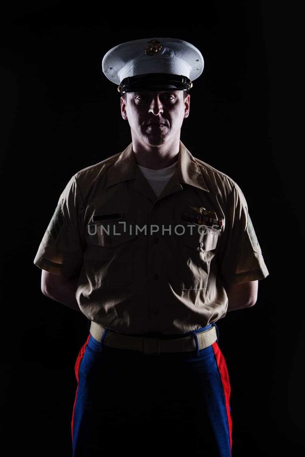 Contour shot of US marine in blue dress uniform on black background