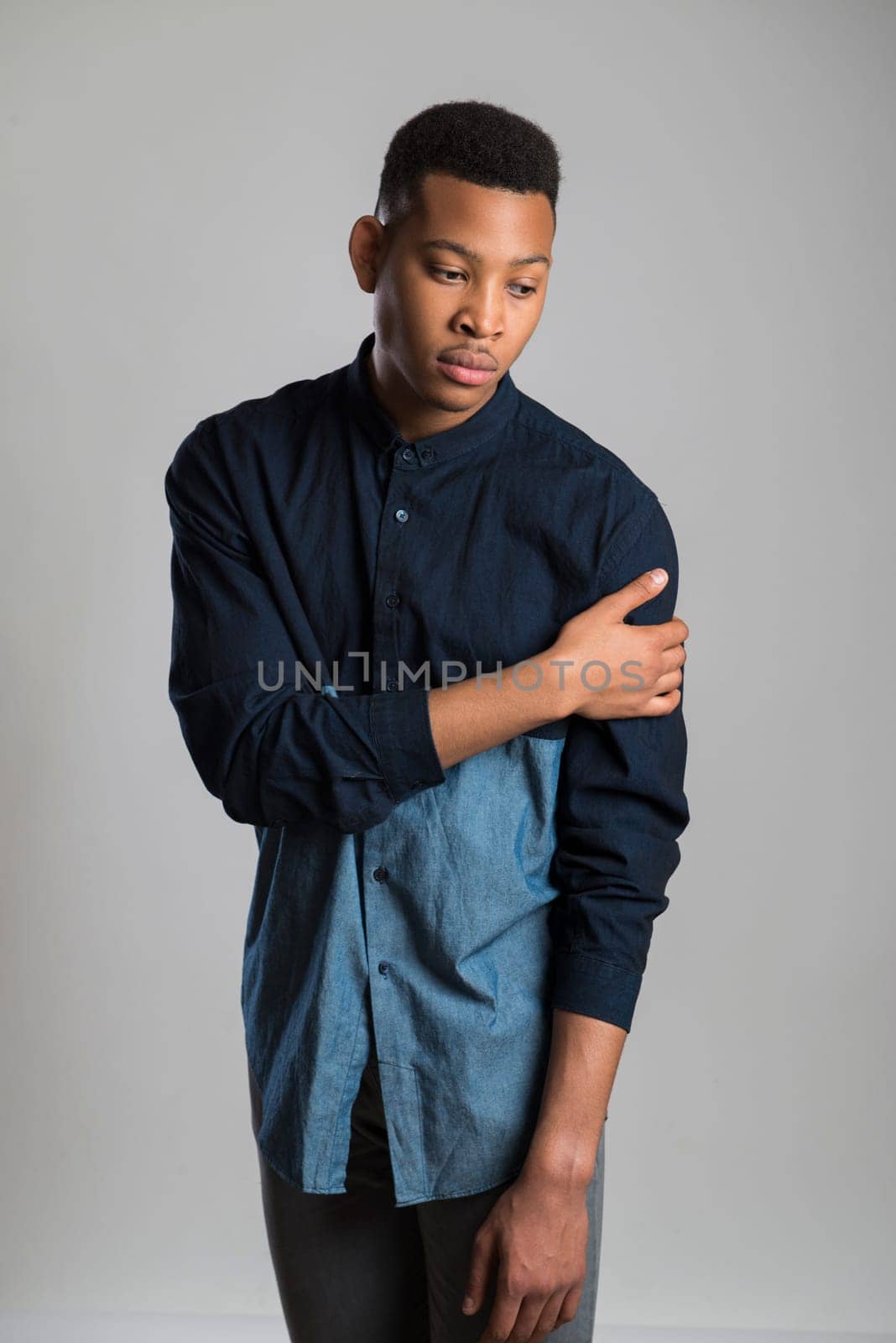 Portrait of handsome dark skinned male model wearing casual clothes against white background
