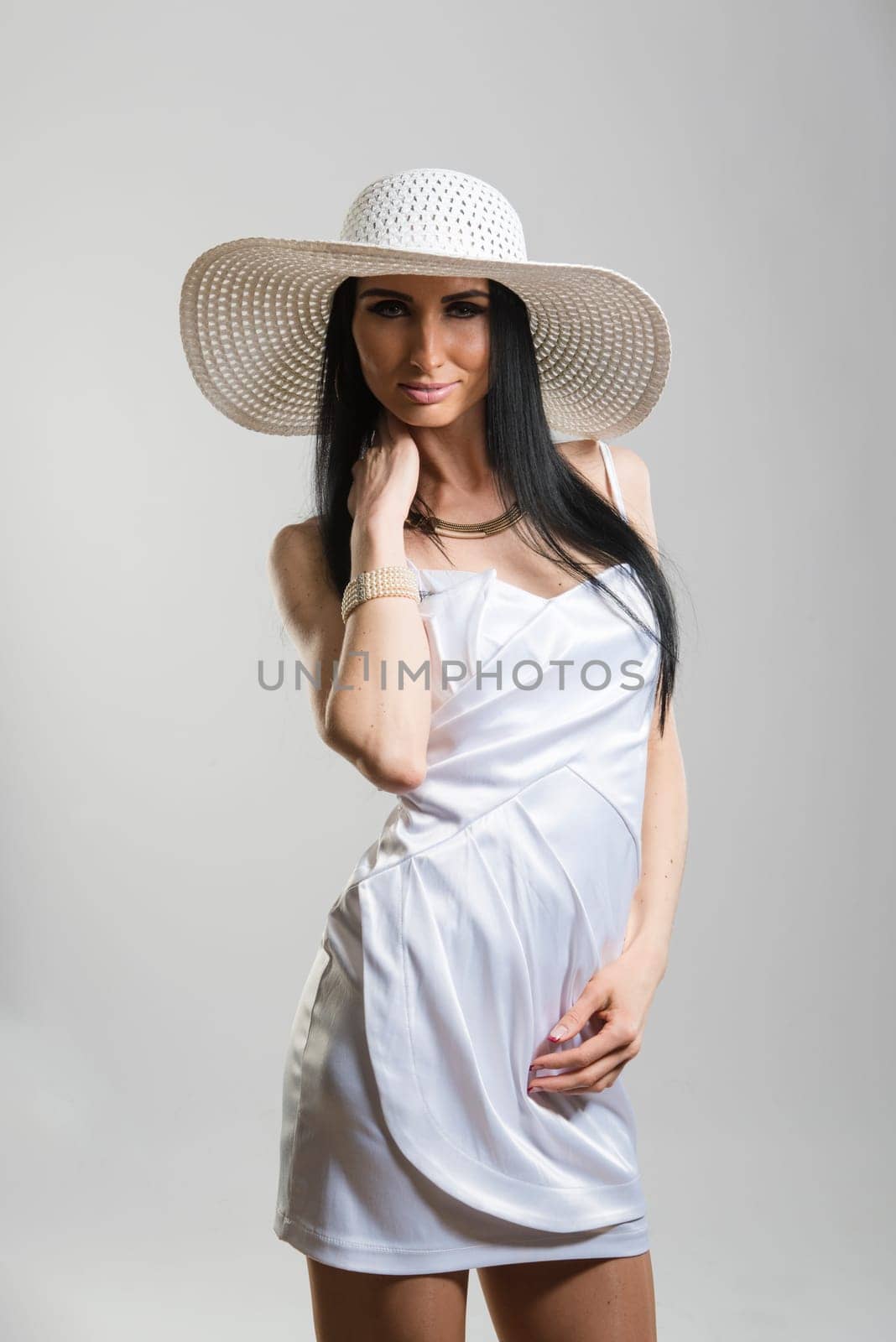 Portrait of beautiful Caucasian woman wearing short white dress and large white hat