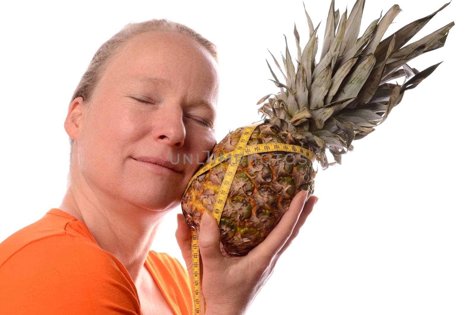 Smiling woman holding a pine apple with a measuring tape