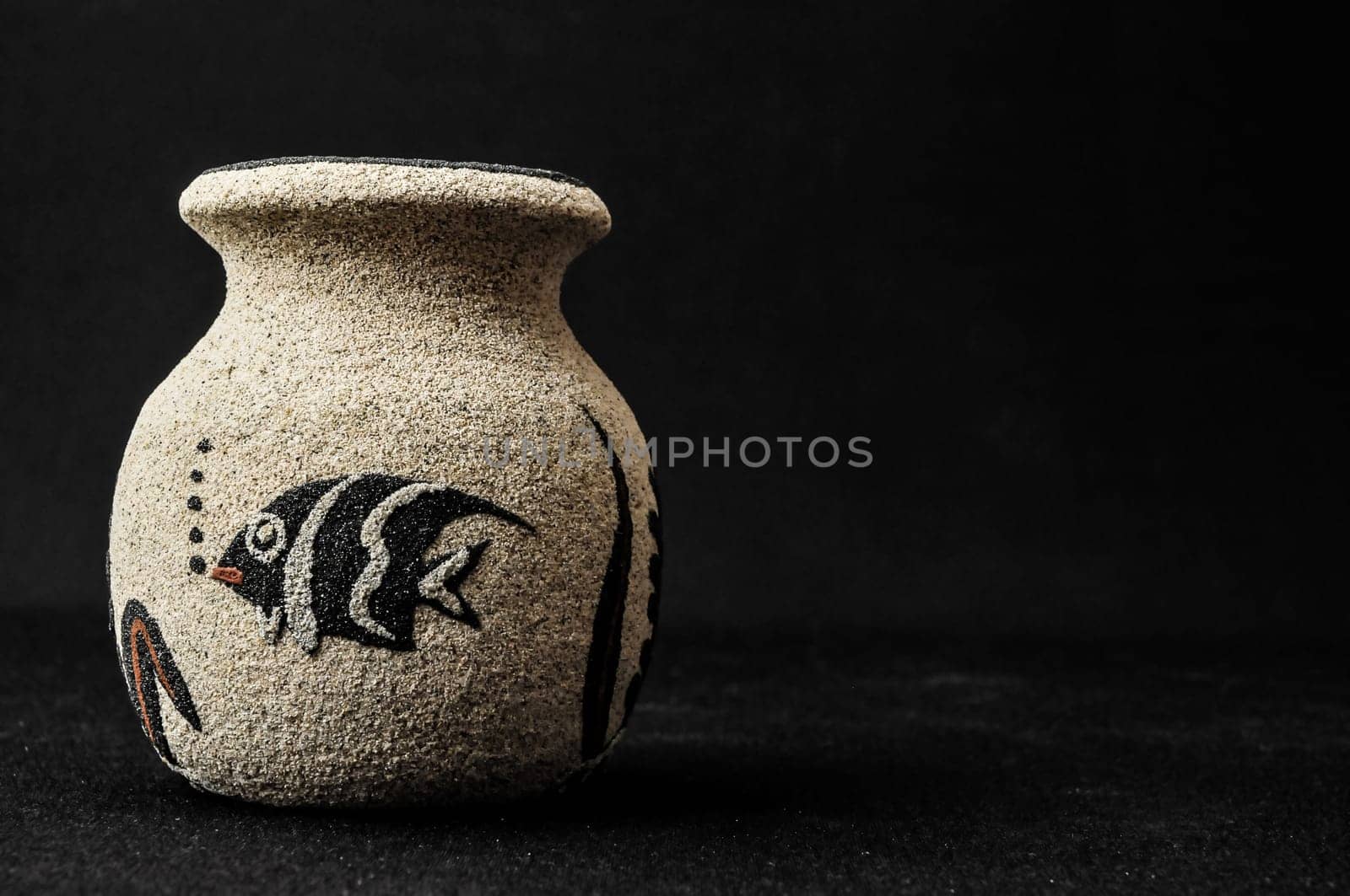 Colorful designed clay vase over a Black background
