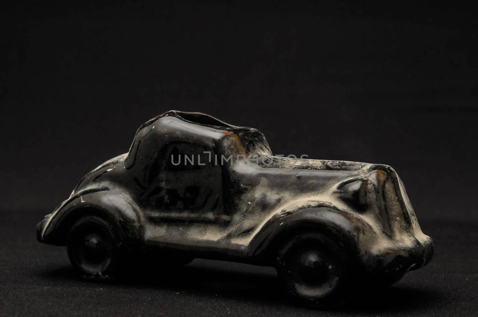 Vintage Old Ceramic Black Car on the Dark background