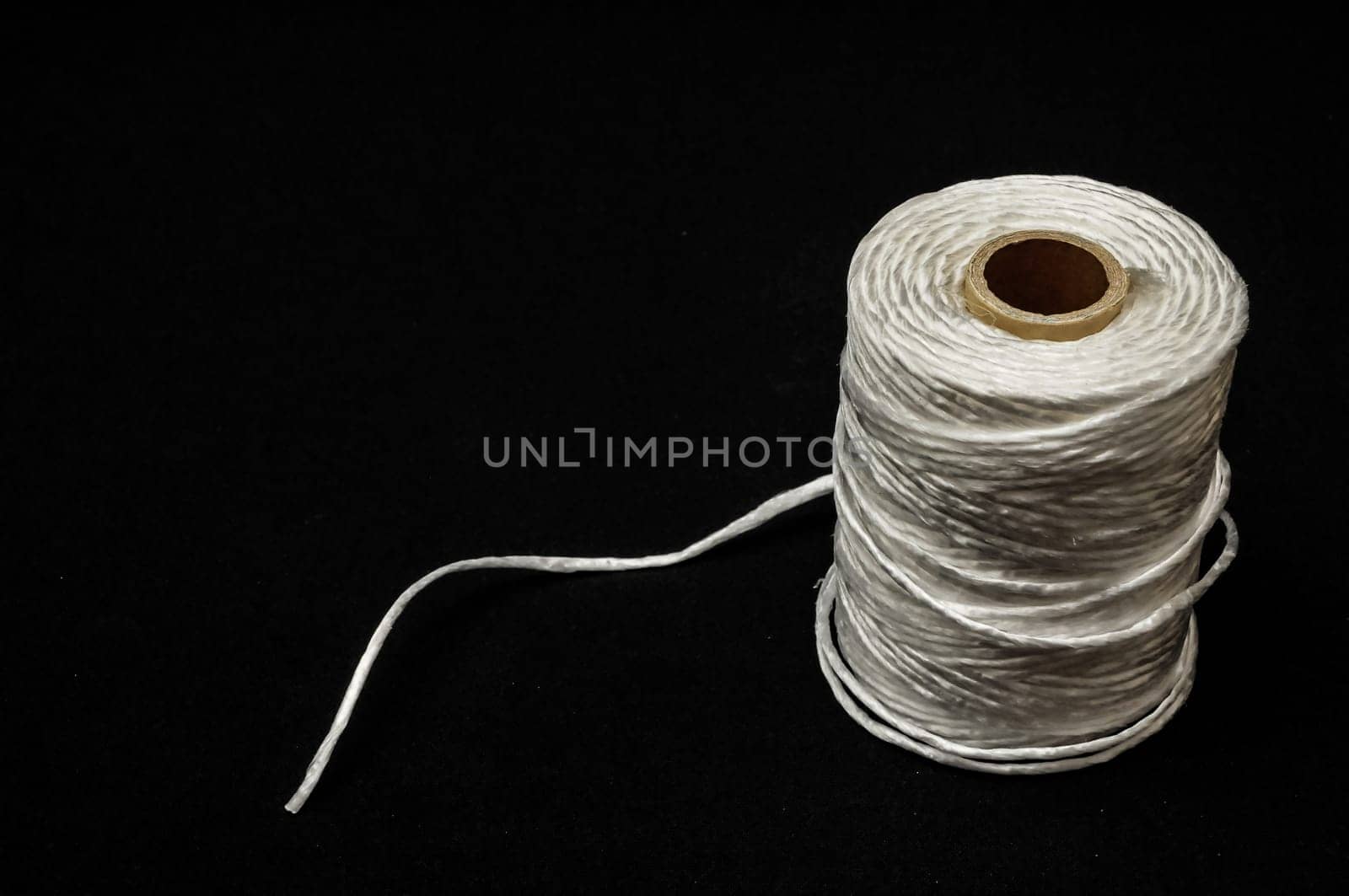 Roll of White Twine on a Black Background