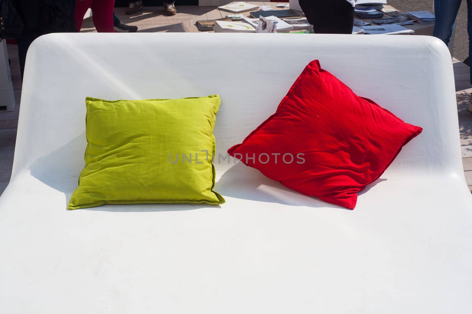 View of green and red pillows on white bed