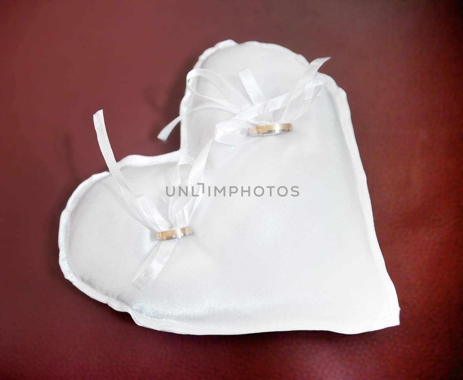 Wedding rings on a white heart shaped pad