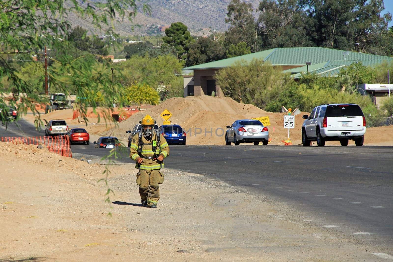 TUCSON, ARIZONA, USA --April 21, 2014:  A Firefighter who is training by running alongside the road with his protective suit and air pack on in Arizona.
