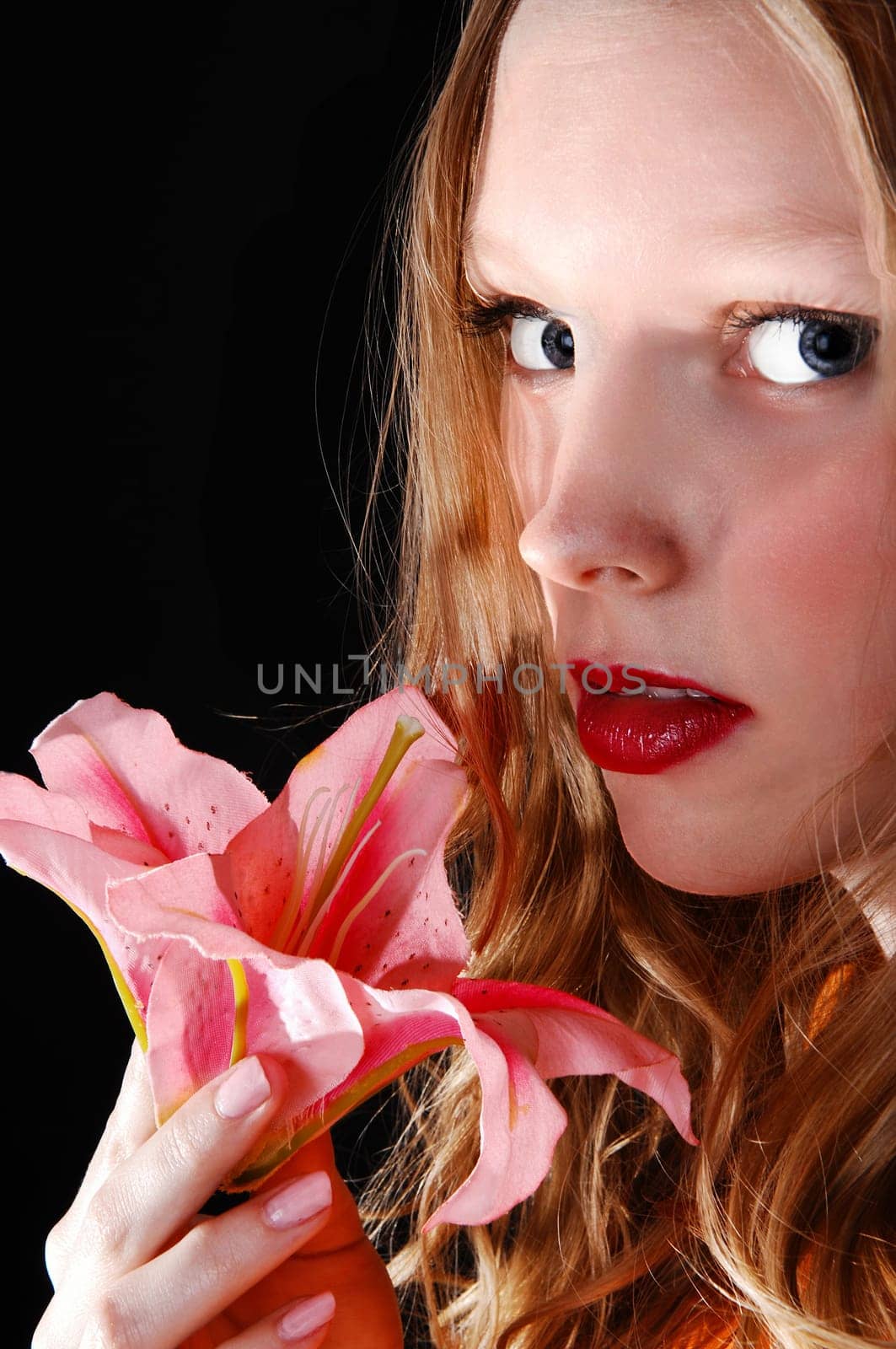 A lovely closeup picture of a young woman holding a pink lily,.isolated for black background..
