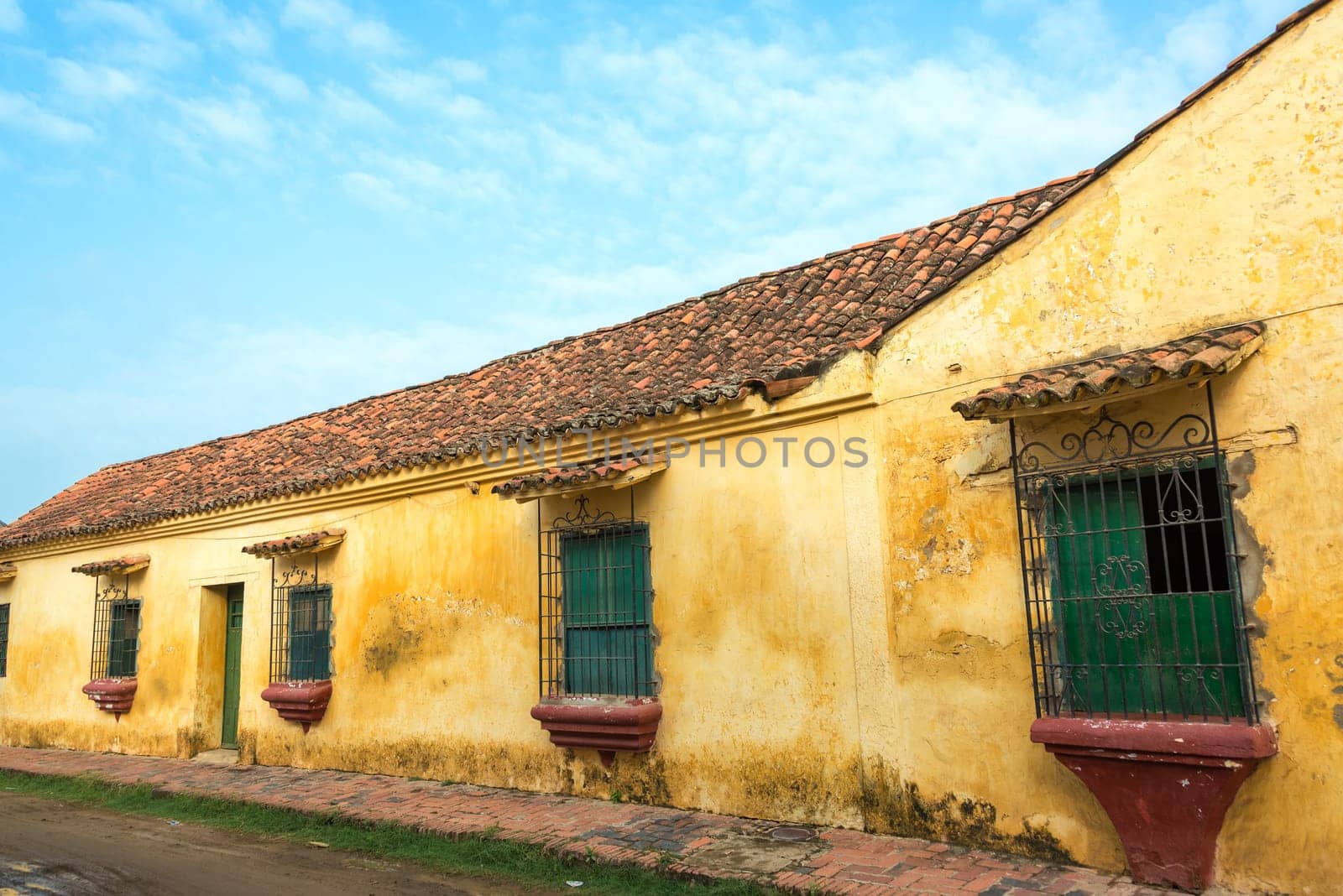Yellow colonial building with green windows in Mompox, Colombia