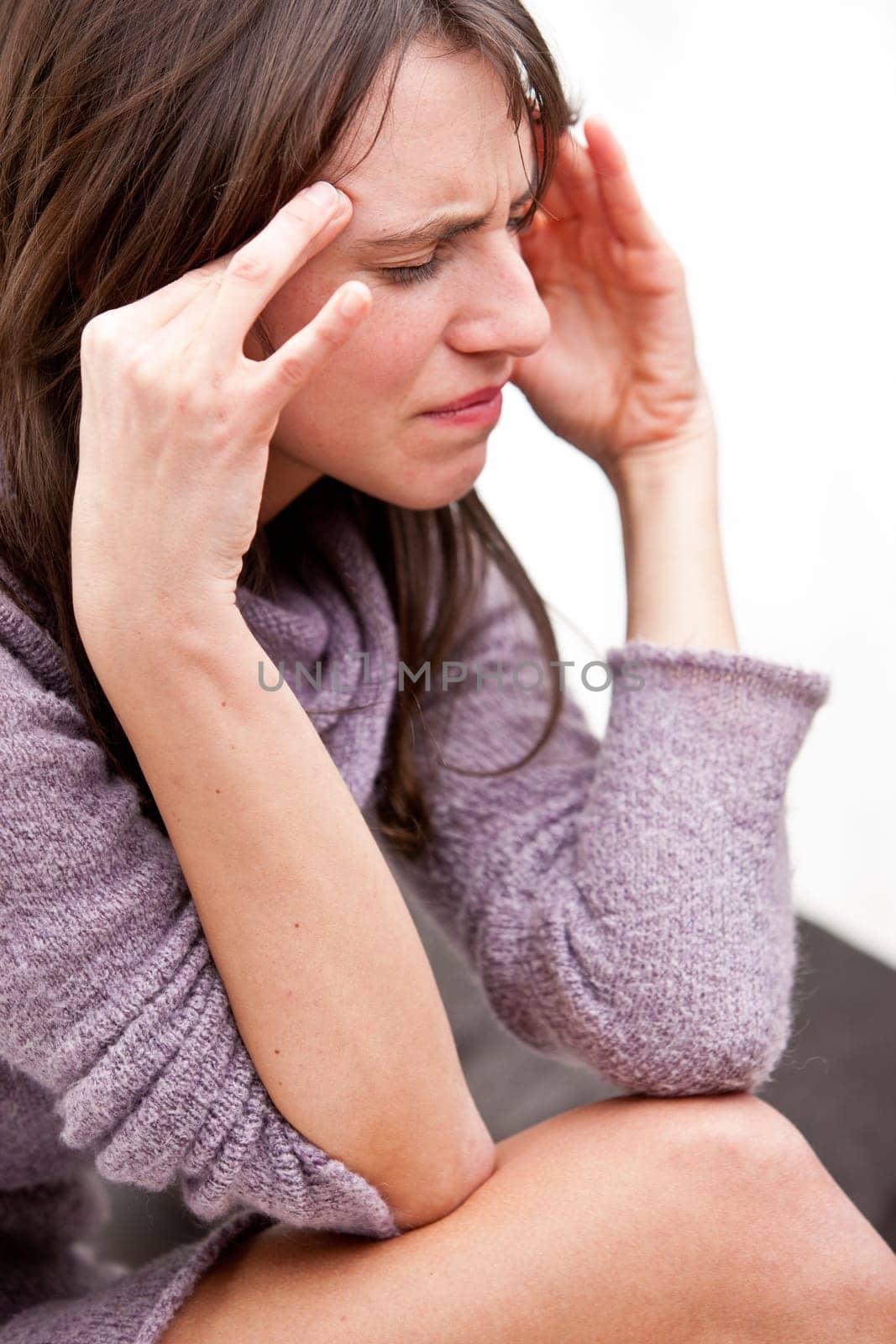 young woman rubbing against her temples because she has a bad headache